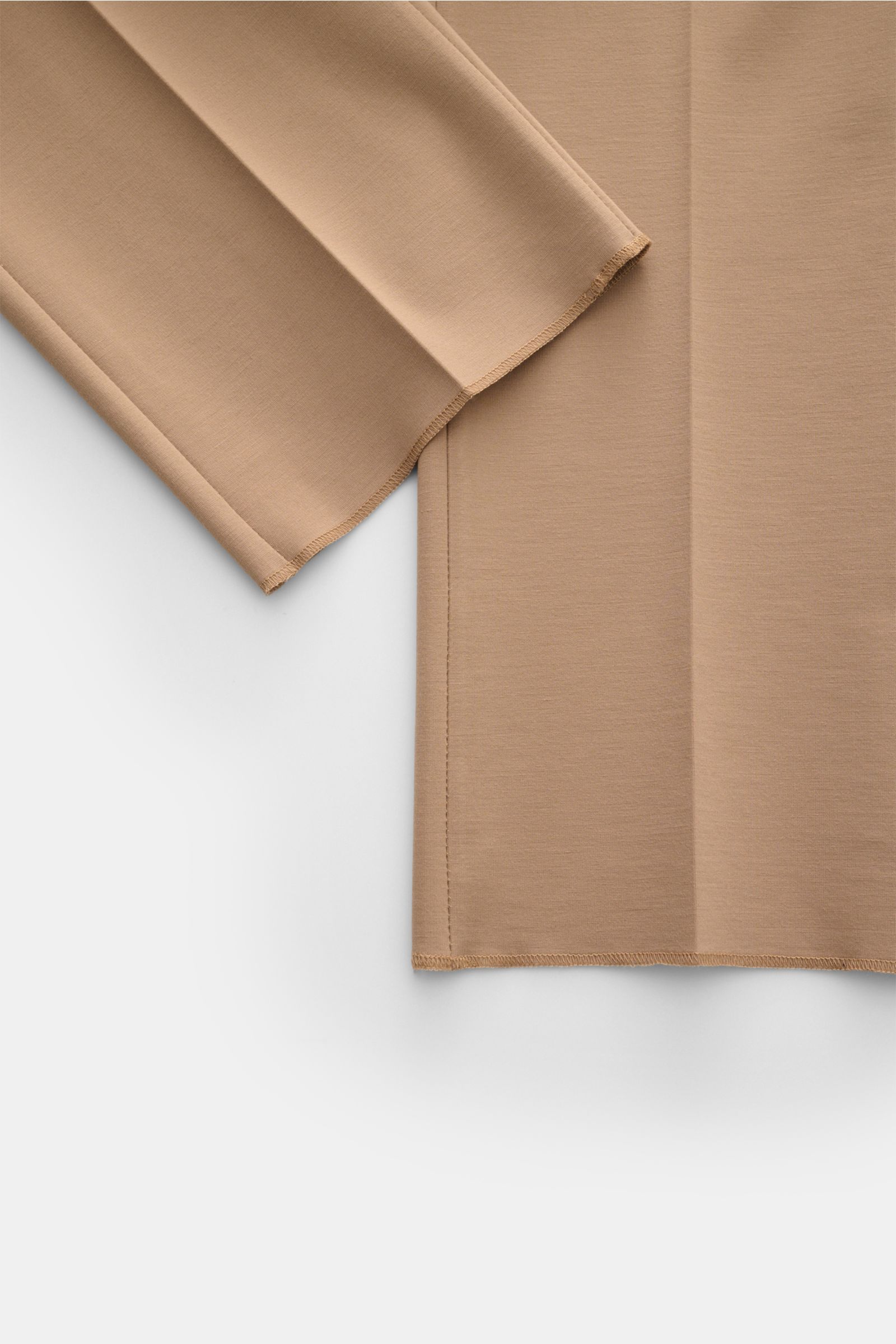 Close-up from above of the leg and hem of GTA Jersey trousers 'Federico' beige, showing soft, elastic jersey fabric with open hem and single pleat. For casual office looks: The jersey trousers 'Federico' by GTA combine maximum comfort with timeless elegan