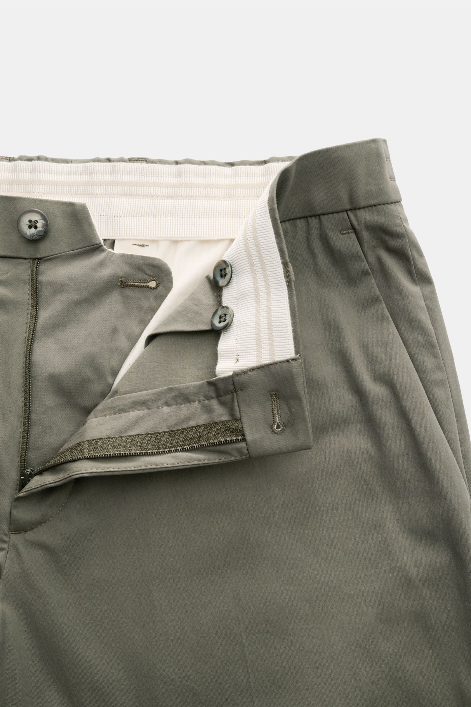 Close-up front view of the GTA Hose 'Davide' graugrün showing open zipper, button, and elastic waistband. Klassiker für die Office-Garderobe: Die leichte Hose von GTA ermöglicht mühelos elegante Business-Looks. Mix aus Baumwolle und Microfaser, leichte Qu