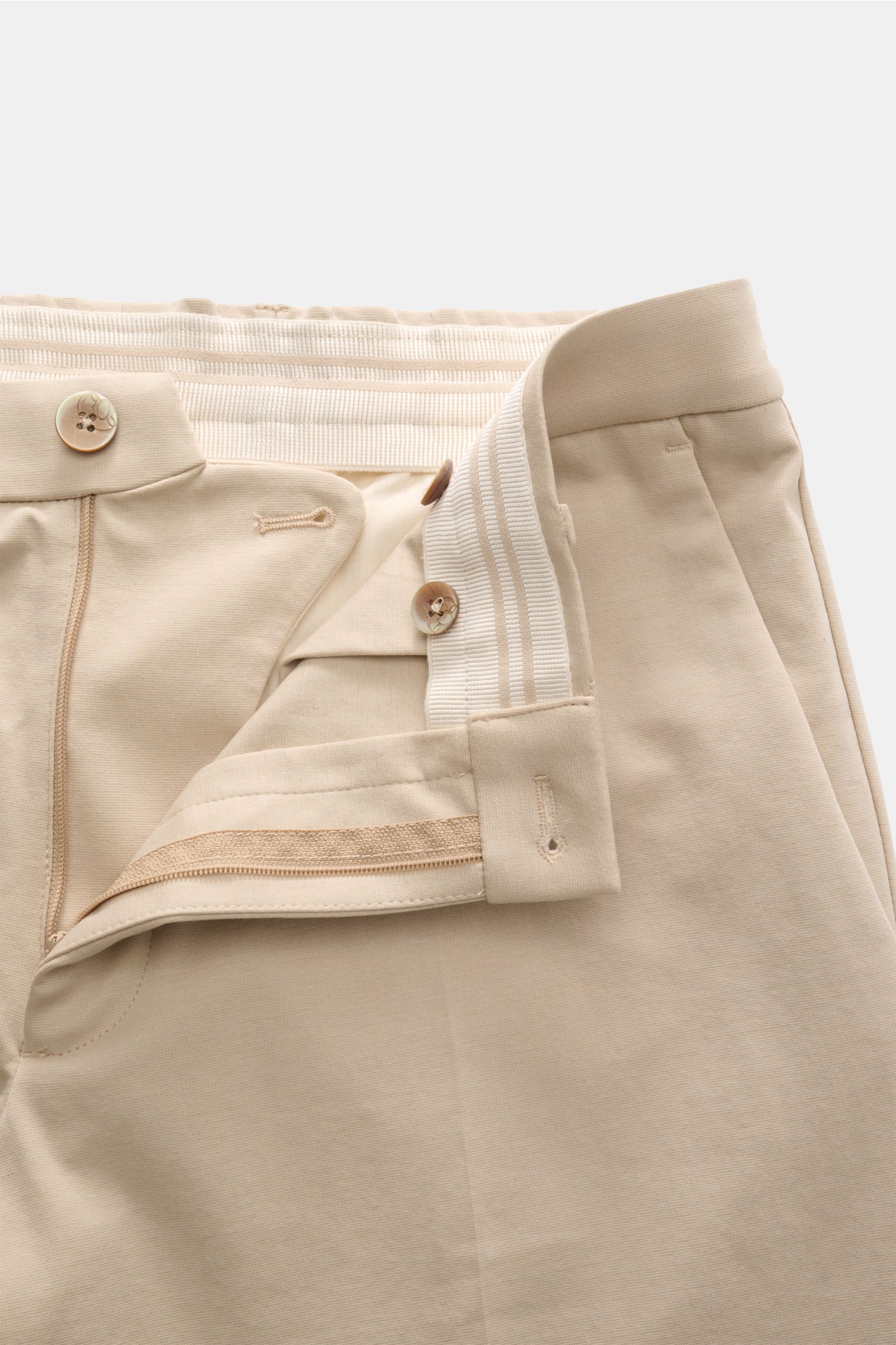 Close-up front view of the GTA Hose 'Davide' sand, showing the waistband, zipper, button, and elastic inner band of the light cotton-mix jersey pants designed for office and leisure versatility. 

Legerer Klassiker für Office und Freizeit: Die leichte 