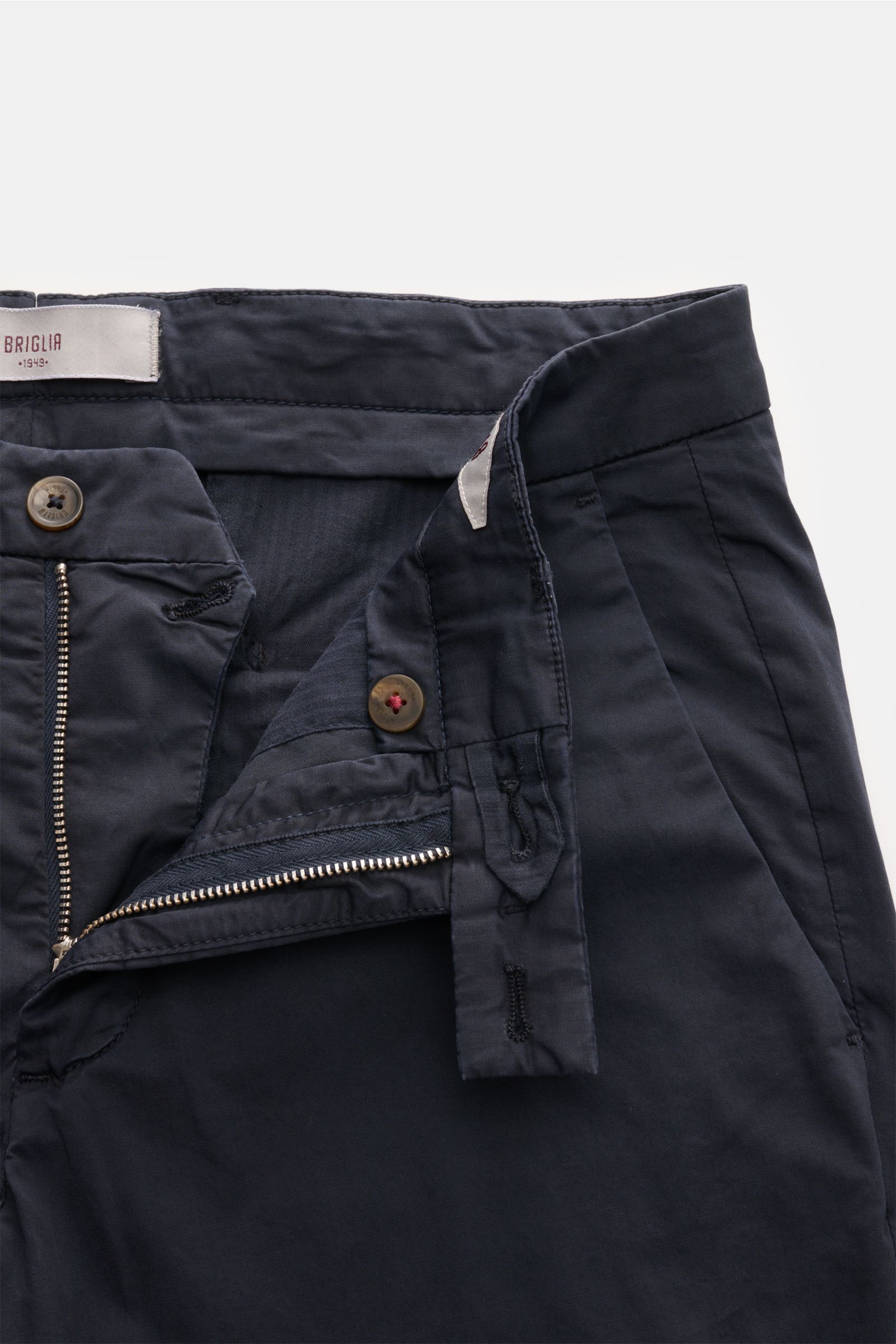 Geöffnete Briglia 1949 Chino navy aus elastischer Baumwolle, weicher Griff, Tapered Fit, knöchellang, mit Reißverschluss, Bundknopf, französischen Taschen, paspelierten Gesäßtaschen, frontale Nahaufnahme.