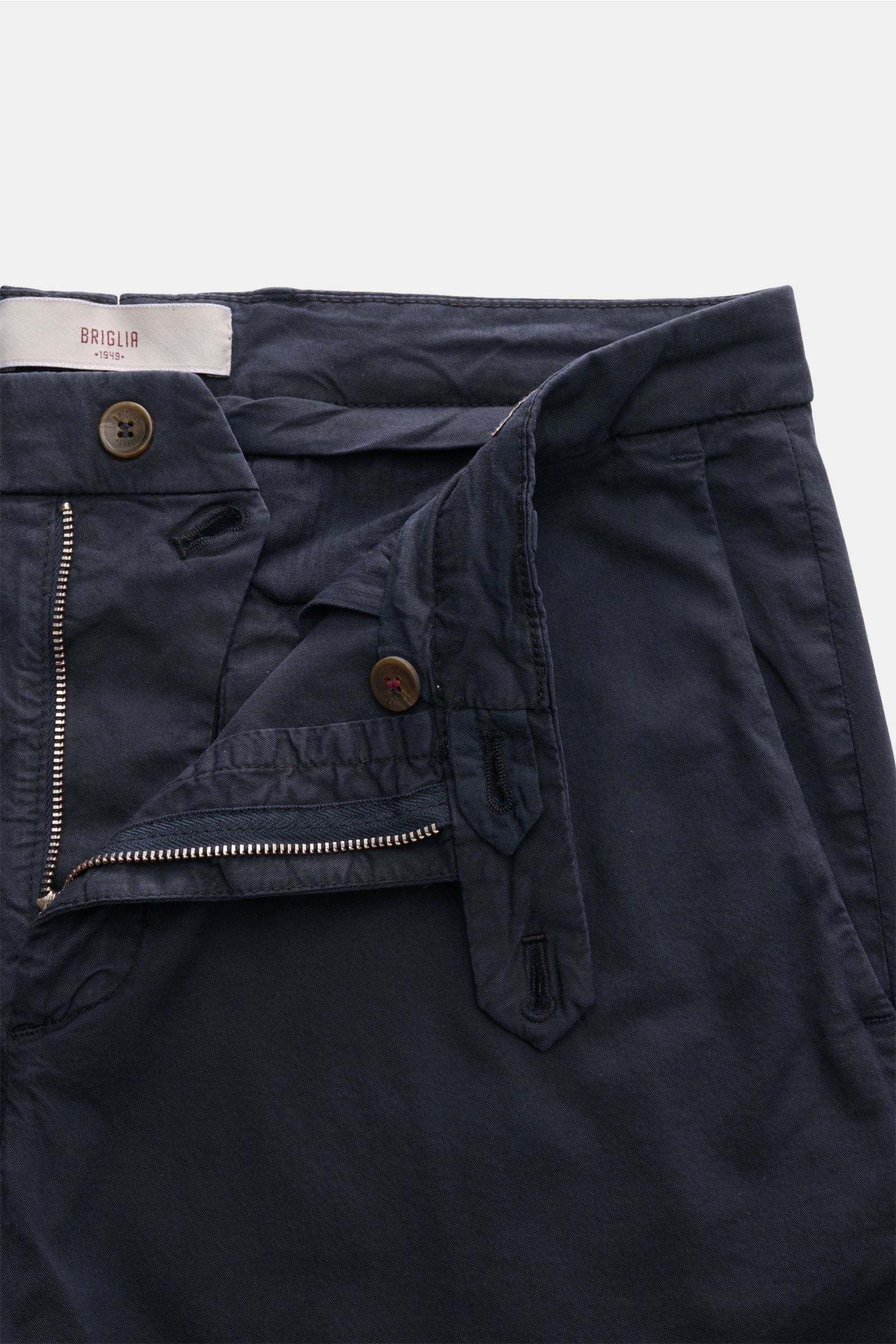Close-up front view of Briglia 1949 Chinos dark navy with open zipper and button, showing elasticated waistband and cotton twill fabric.

Maximum comfort meets an elegant silhouette: Summery ease meets timeless aesthetic in these chinos by BRIGLIA 1949