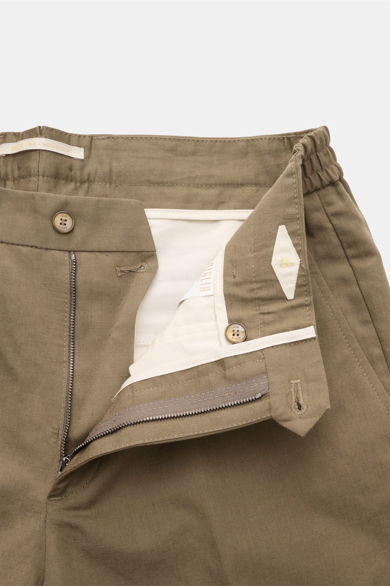 Nahaufnahme der geöffneten Bund- und Reißverschlusspartie der Briglia 1949 Chino 'Portofino' taupe aus Baumwoll-Leinen-Twill, leicht griffig, mit Bundfalte und Knopftaschen.