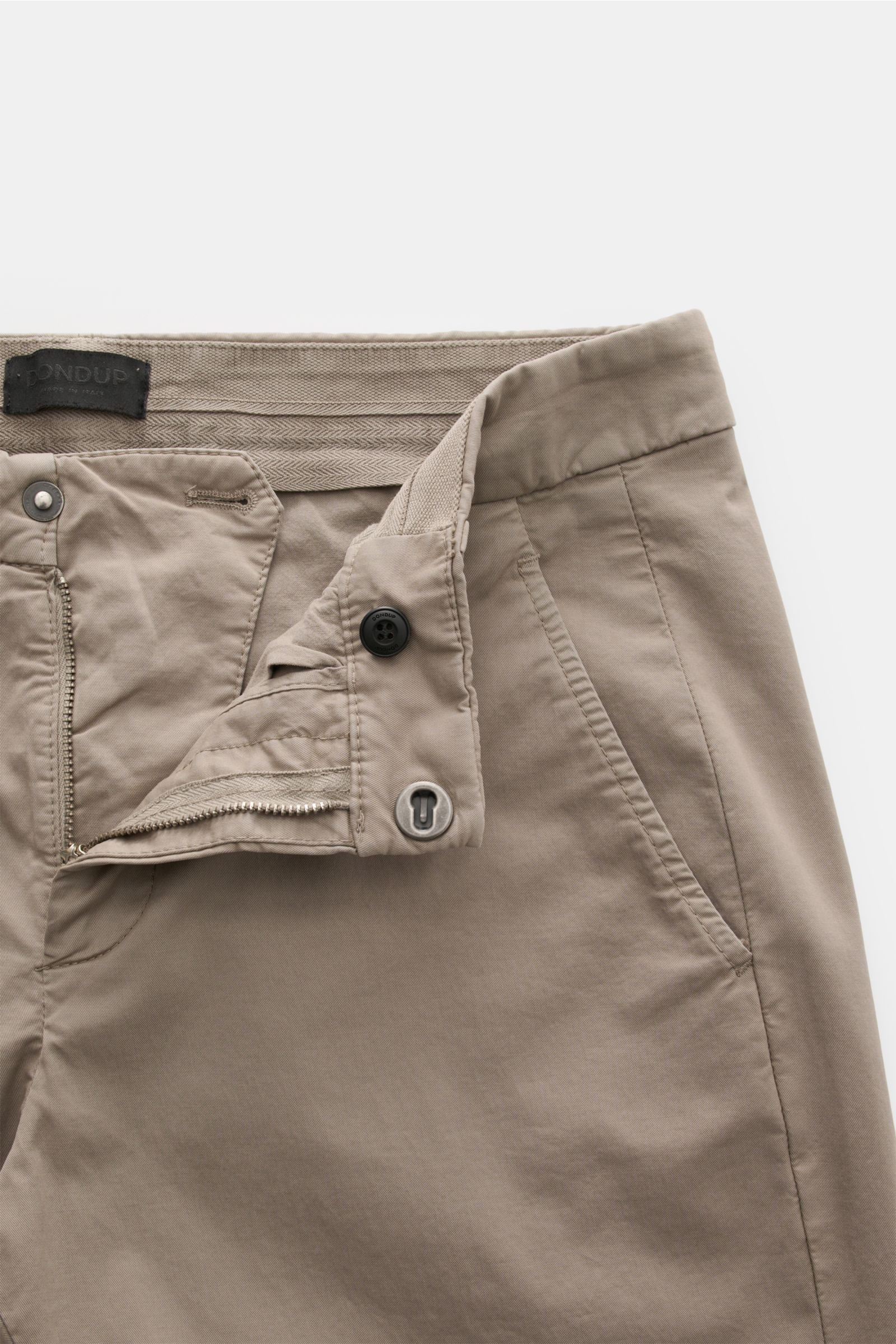 Dondup Chino 'Gaubert' taupe, Slim Fit, nah aufgenommen von vorne, leicht elastische Baumwolle, garment dyed, Metall-Initial, französische Taschen.
