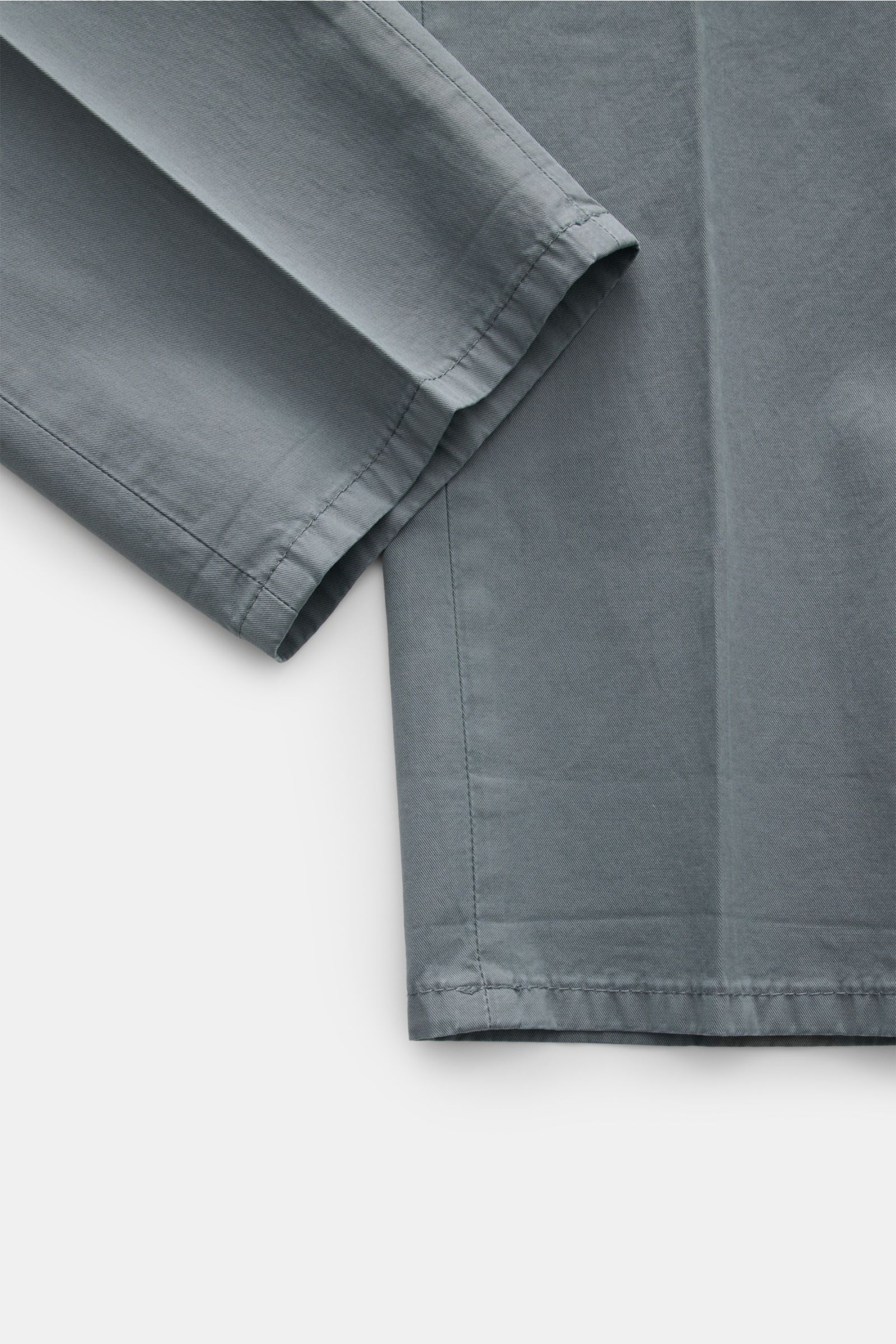 Dondup Chino 'Gaubert' graublau, Detailaufnahme der schmal geschnittenen Wade aus leicht elastischer, garment-dyed Baumwolle mit feiner Köperstruktur.
