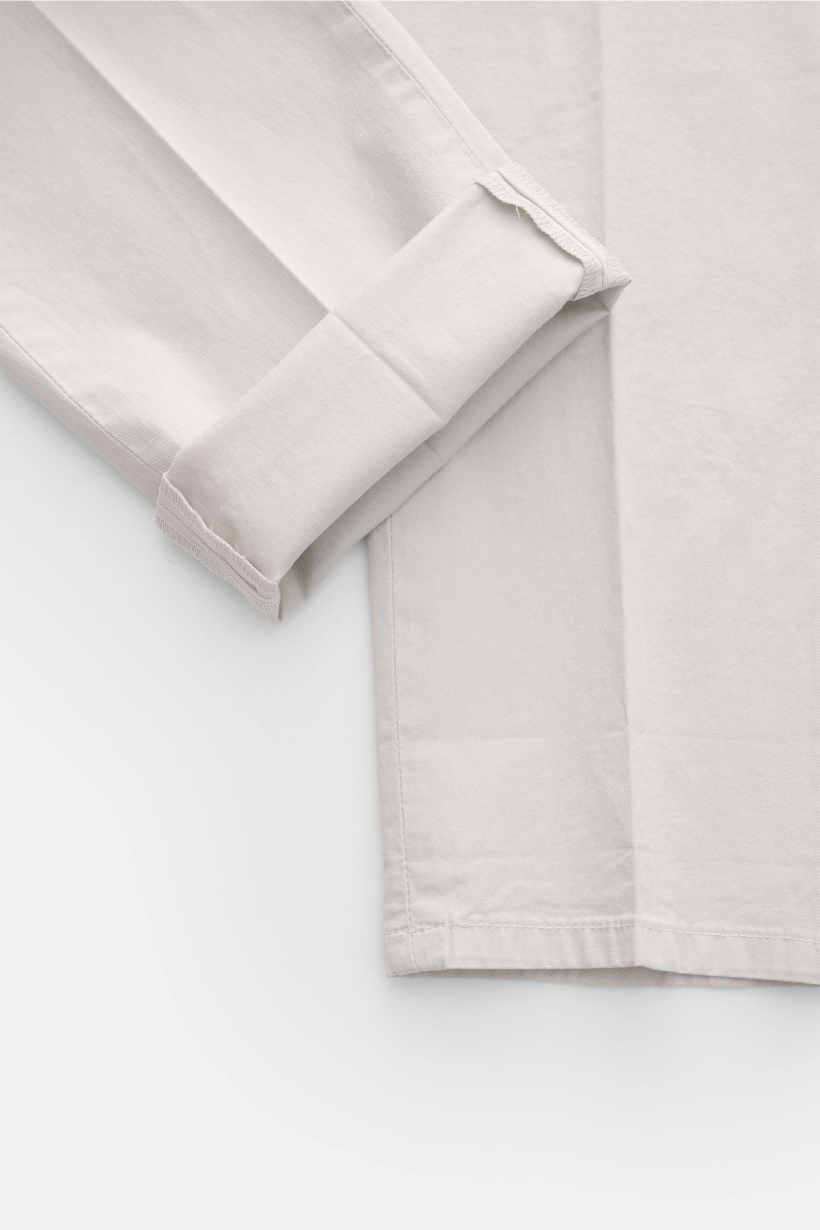 Dondup Chino 'Gaubert' hellgrau aus leicht elastischer Baumwolle, Slim Fit, feine Köperstruktur, Detailansicht Saum und Bein von oben.