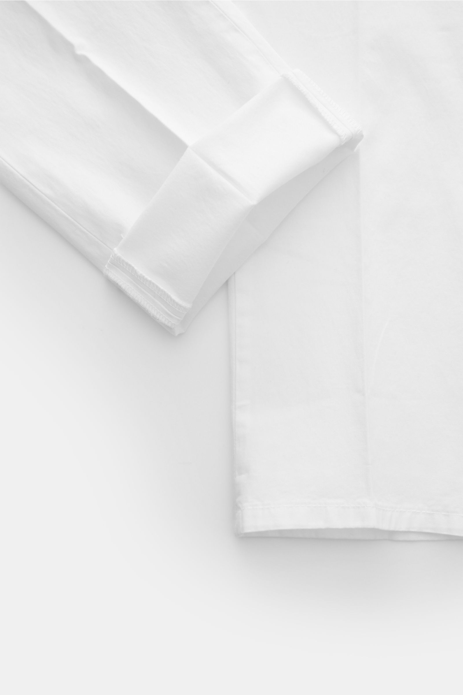 Dondup Chino 'Gaubert' weiß, Nahaufnahme von Bein und Saum, slim Fit, leicht elastische Baumwolle, garment dyed, Metall-Initial sichtbar.