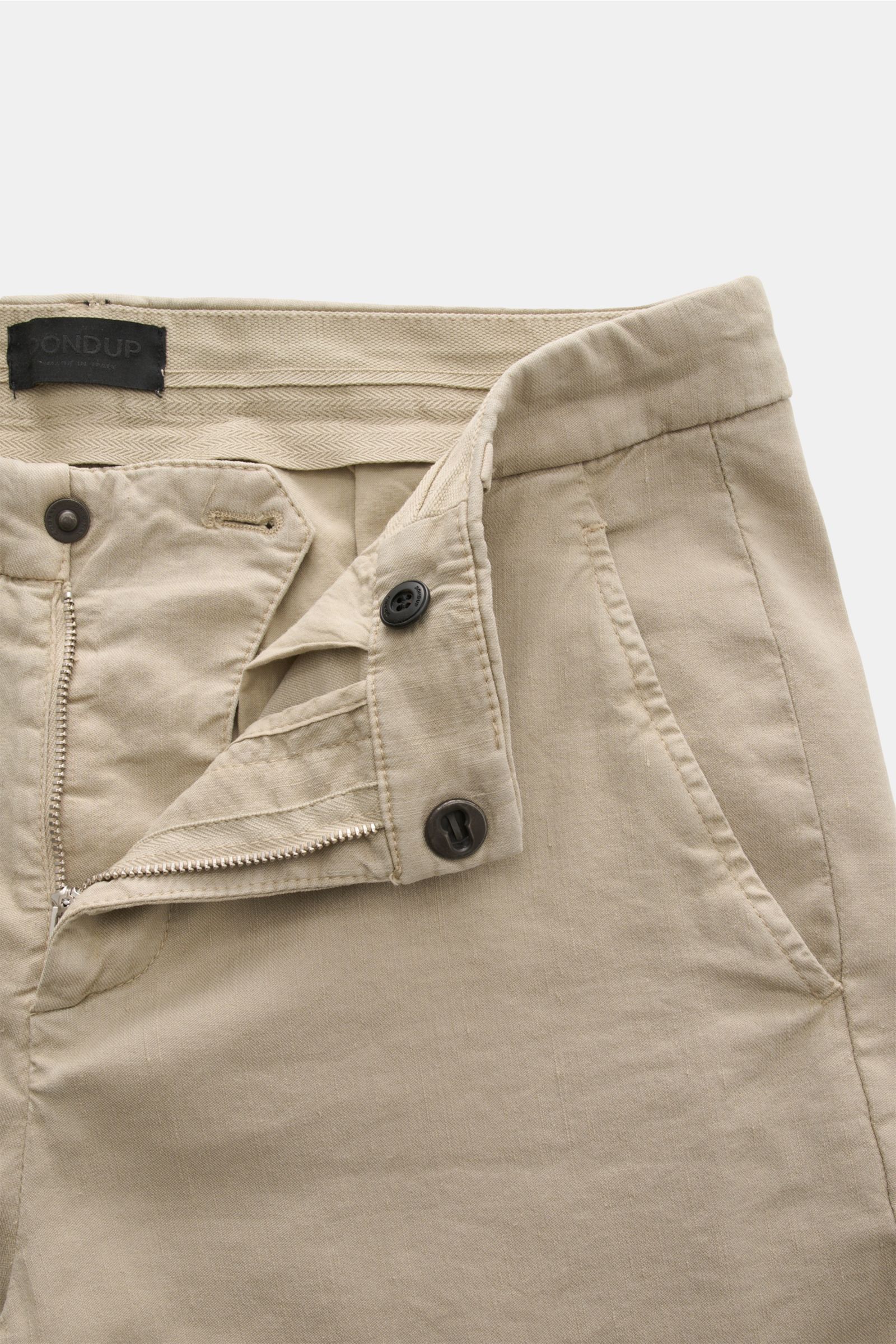 Close-up front view of Dondup Hose 'Gaubert' beige pants, showing zipper, button fly, and pockets. Smart Casual mit Komfort: Die Hose 'Gaubert' von DONDUP kombiniert klare Schnittführung mit elastischer Qualität für entspannte Eleganz. Mix aus Leinen und 
