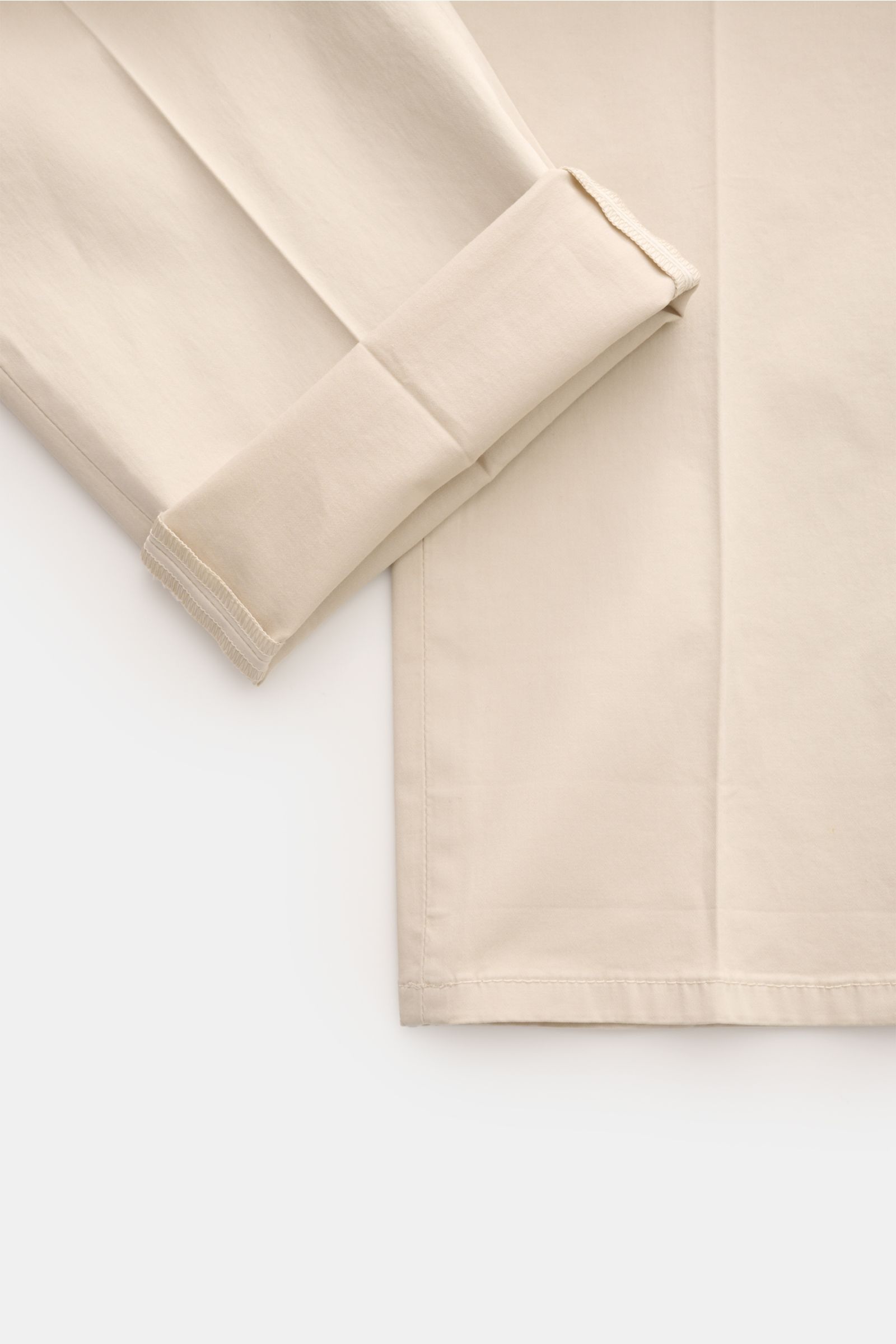 Close-up front-side view of the lower legs of Dondup Baumwollhose 'Gaubert' sand, slim fit, made of lightly elastic, soft cotton with a folded hem. Für alle Liebhaber von italienischer Mode: mit diesem Modell von DONDUP sind Sie bestens beraten, wenn es u