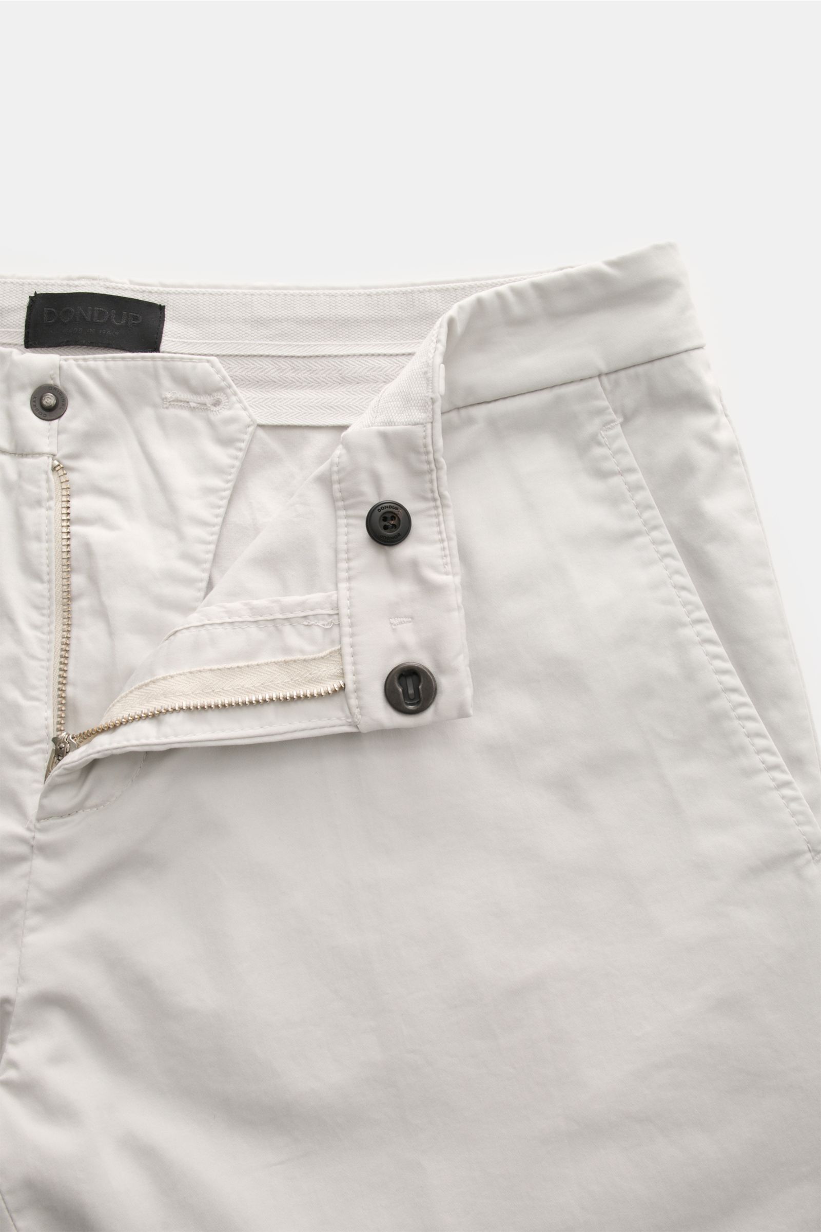 Dondup Baumwollhose 'Gaubert' hellgrau aus elastischer Baumwolle, Slim Fit, schmal geschnitten, Reißverschluss, Slide Button, französische Taschen, Metall-Initial, Detailaufnahme von oben.