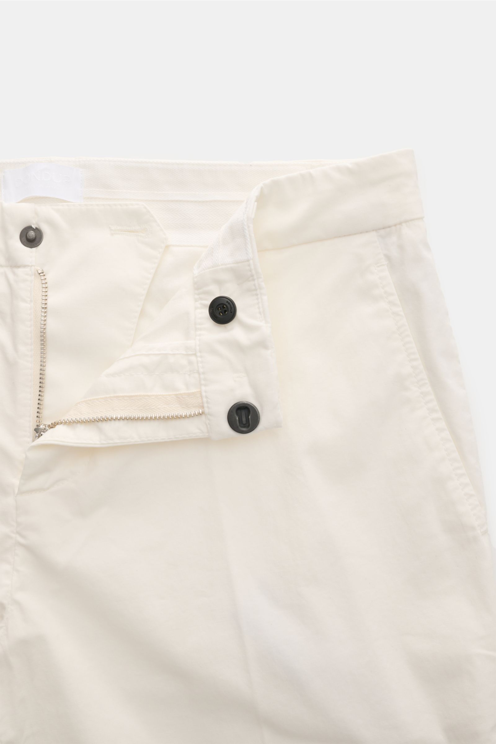 Dondup Baumwollhose 'Gaubert' offwhite, schmal geschnitten, Slim Fit, leicht elastisch, mit Reißverschluss, Slide Button und französischen Taschen, Nahaufnahme frontale Perspektive.