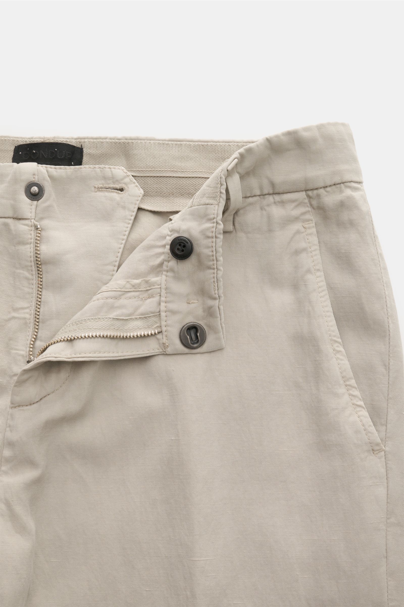 Nahaufnahme der Dondup Chino 'Gaubert' beige mit geöffnetem Reißverschluss, Slide Button, französischen Taschen und garment dyed Finish.