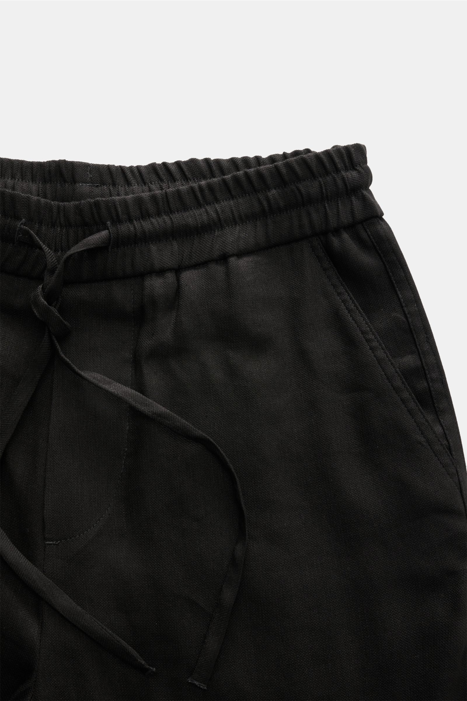 Close-up top-front view of Kiefermann Jogger pants 'Haltor' black, showing elasticated waistband with drawstring and French pocket. Pared down to the essentials and made for a carefree summer: German label KIEFERMANN is synonymous with puristic menswear w