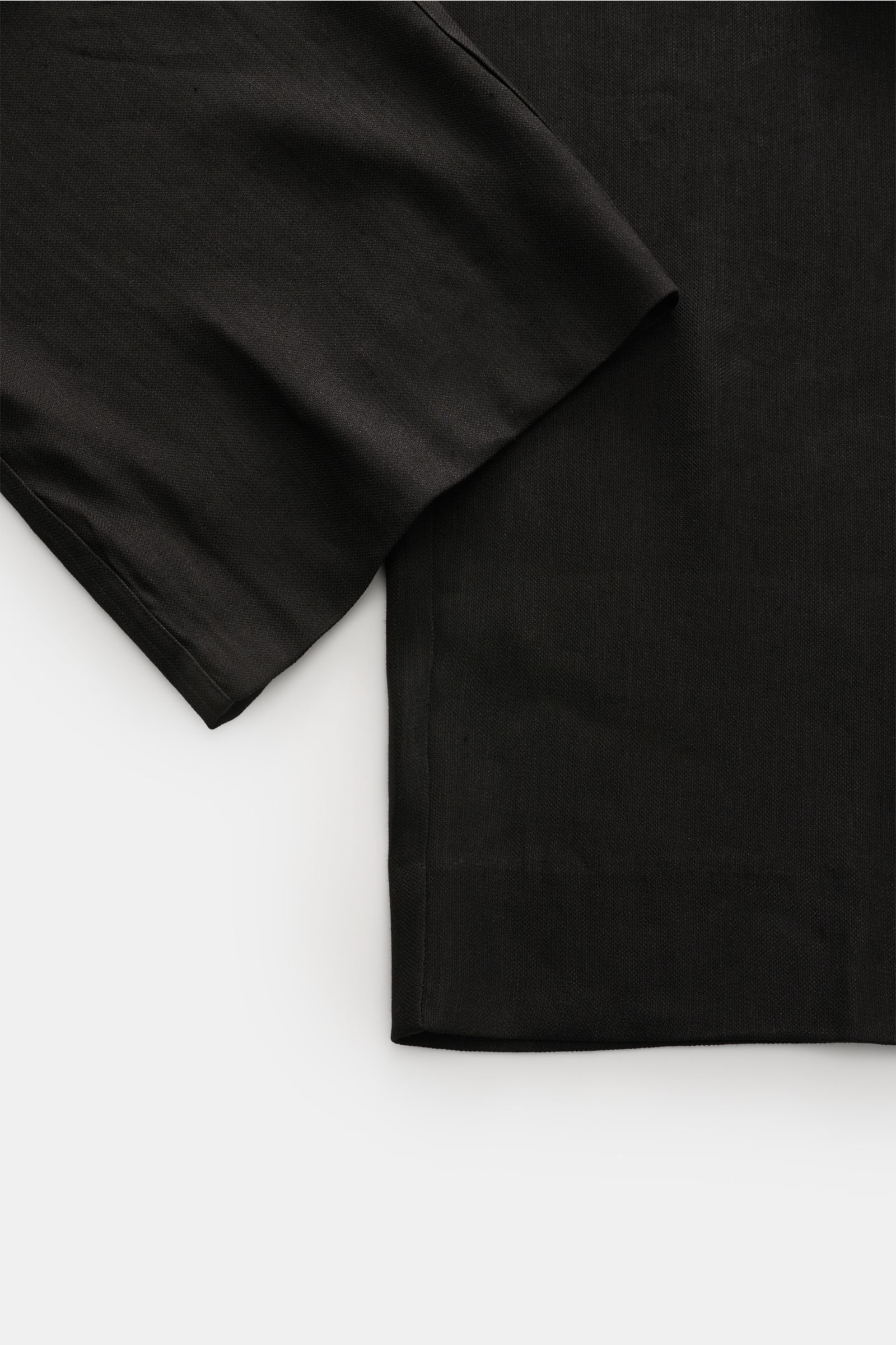 Close-up of the short, straight cut hem of Kiefermann Jogger pants 'Haltor' black, photographed from above, showing fine weave and soft linen-viscose fabric. Pared down to the essentials and made for a carefree summer: German label KIEFERMANN is synonymou
