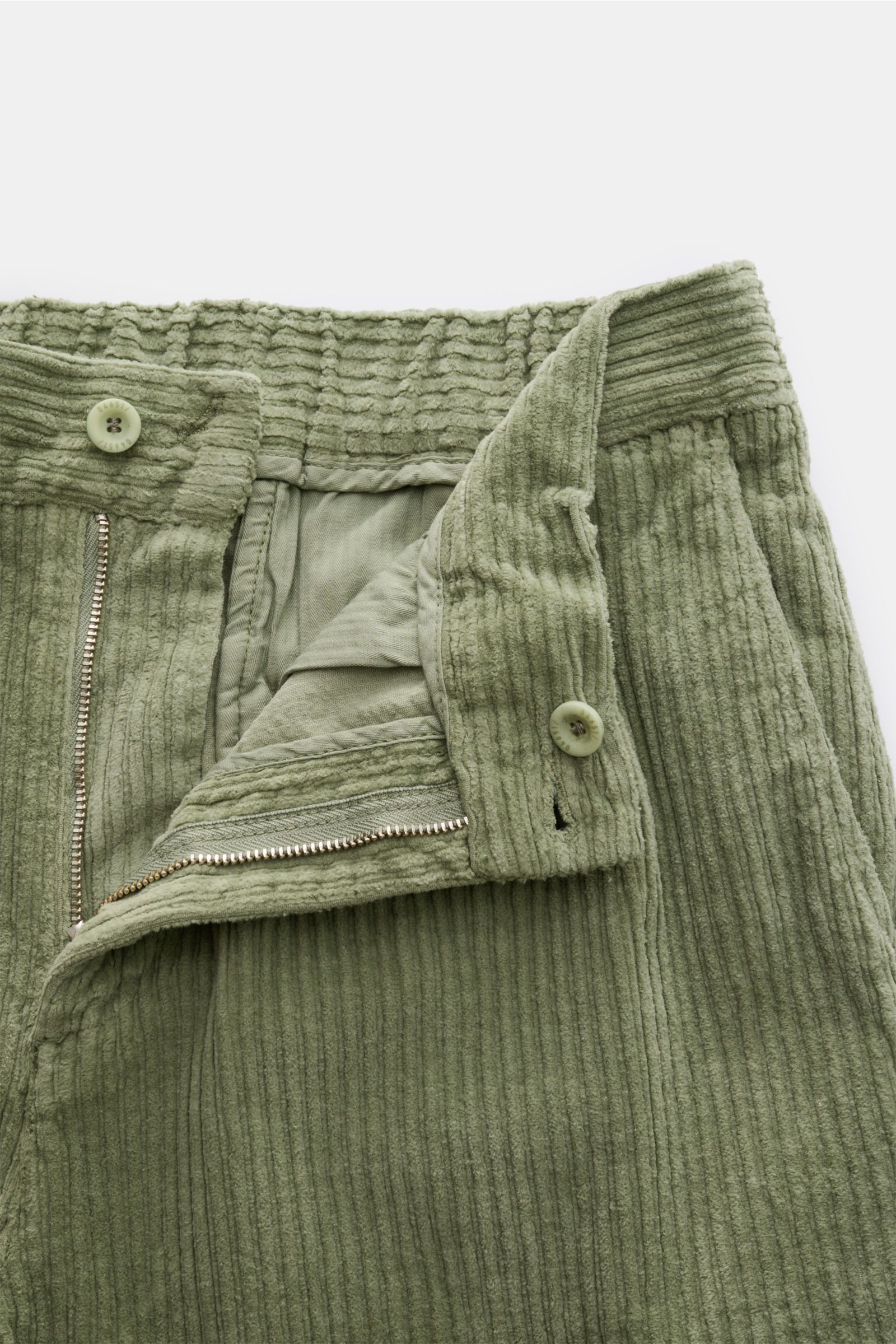 Nahaufnahme der geöffneten Taille der 04651/ A trip in a bag Cord-Cargohose salbei aus elastischem Cord mit Reißverschluss und Knopf.