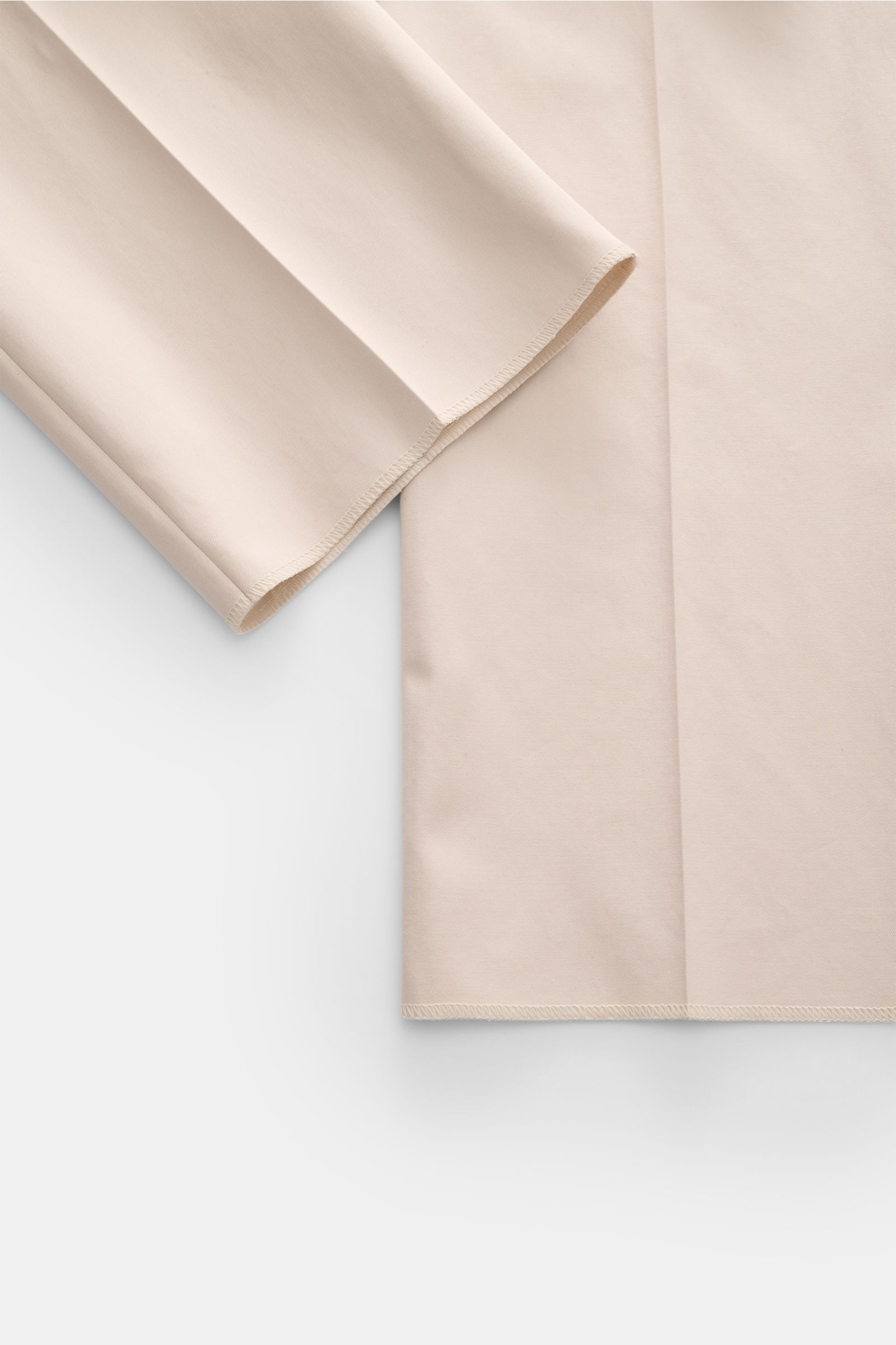 Moorer Jogger pants 'Anton' beige shown from a close-up side angle, highlighting lightweight cotton twill fabric, soft feel, regular fit with slightly tapered cut, open hem length, and neat stitching details. The trousers feature a summery lightweight fab