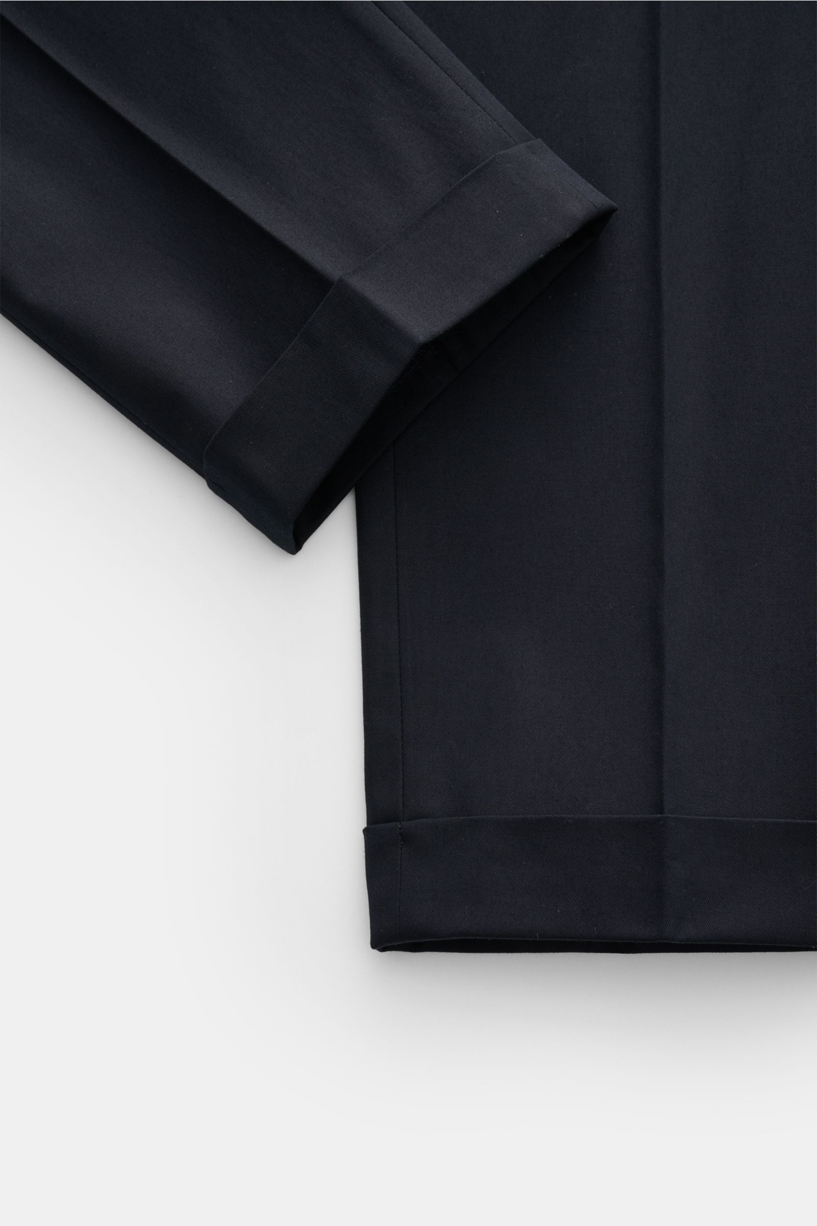 Close-up top-down view of Berwich Chino 'Barber' navy cotton twill pants with cuffed hem, showing smooth fabric and fine stitching, featuring lightweight stretch for comfort and durable double pleats.

Additional description: 
Die Chino 'Barber' von BE