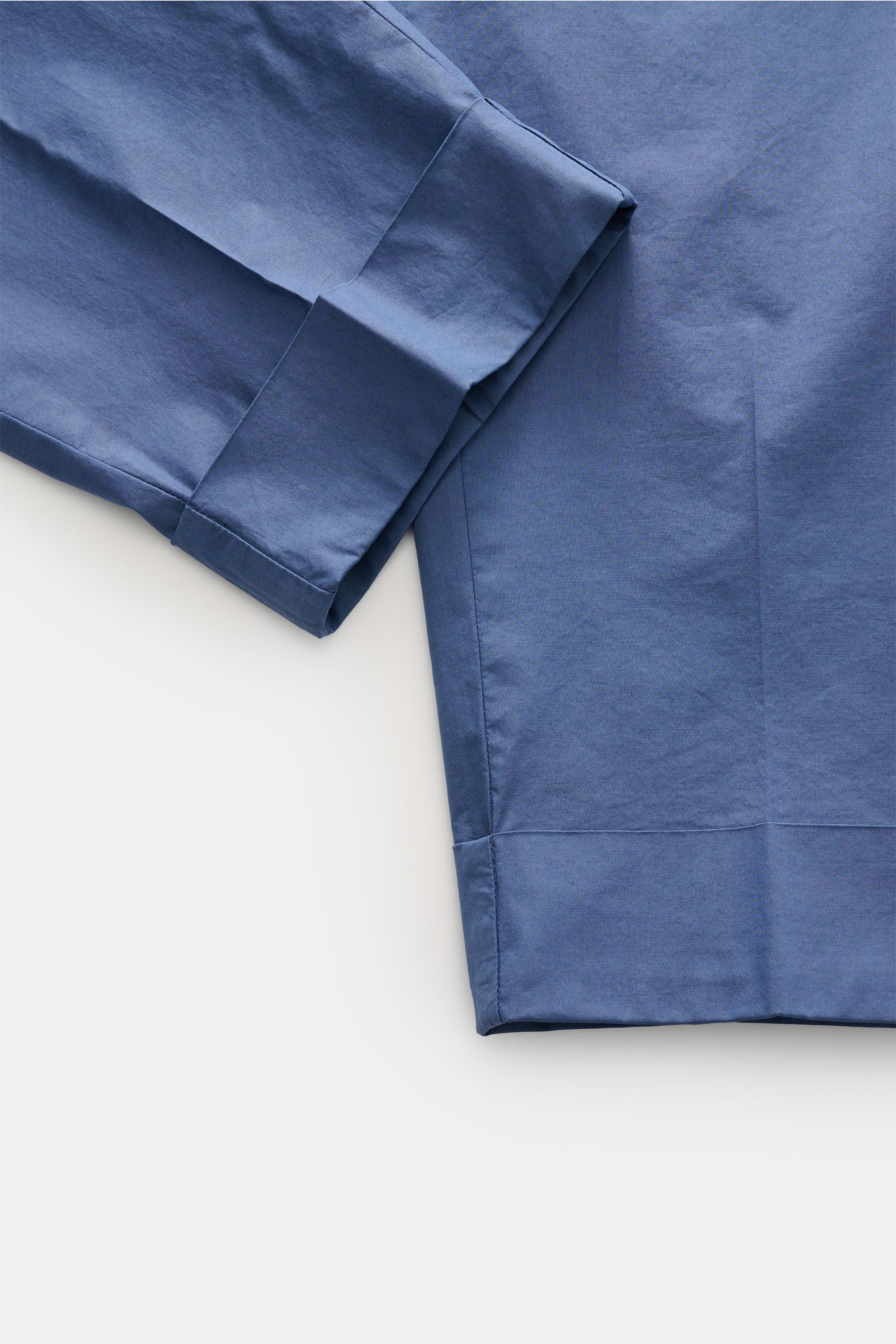 Berwich Hose 'Chiaia' graublau shown from a top-down close-up of folded pant legs, made of cotton and lyocell, soft touch, tapered fit, ankle-length with fixed cuff. Entspannter Stil für die wärmere Jahreszeit: Die Hose 'Chiaia' von BERWICH überzeugt mit 