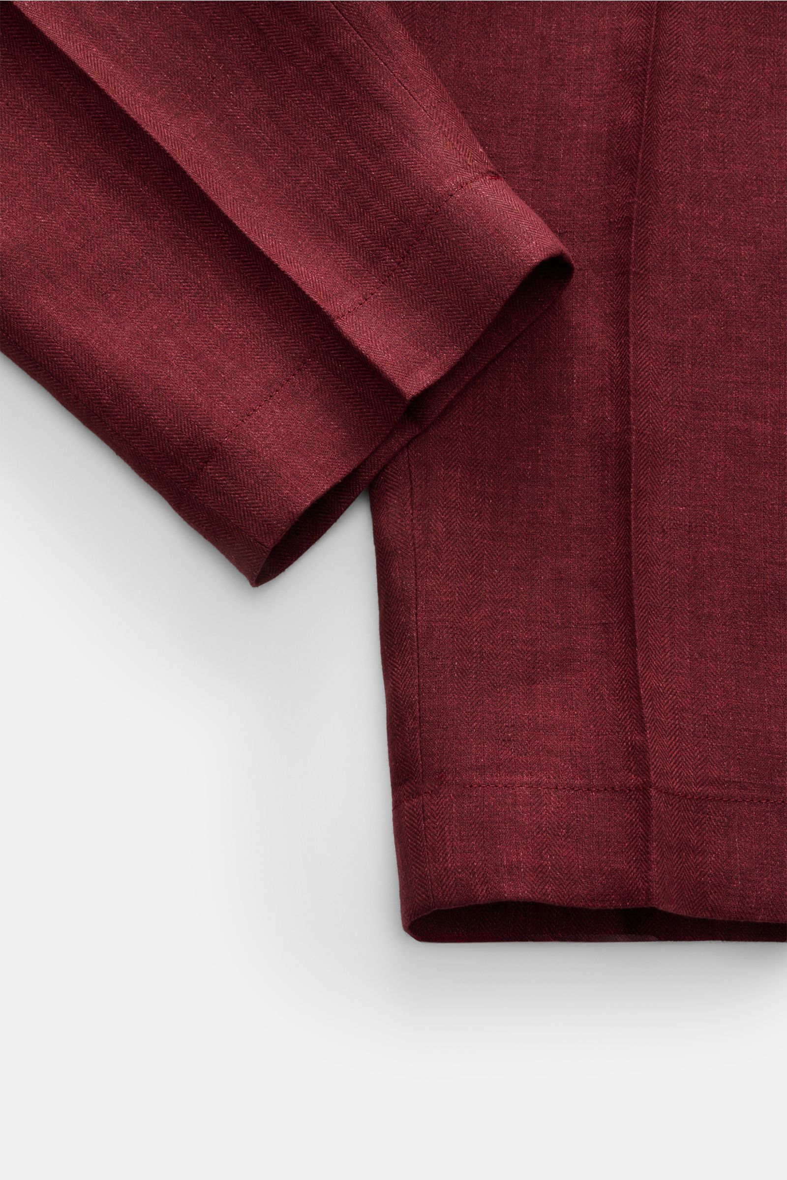 Berwich Leinenhose 'Chiaia' bordeaux close-up from above showing fine herringbone texture and deep red pure linen fabric detail.  
Sommerliche Leichtigkeit verspricht die Hose 'Chiaia' von BERWICH aus reinem Leinen – die materialtypische Haptik und die st