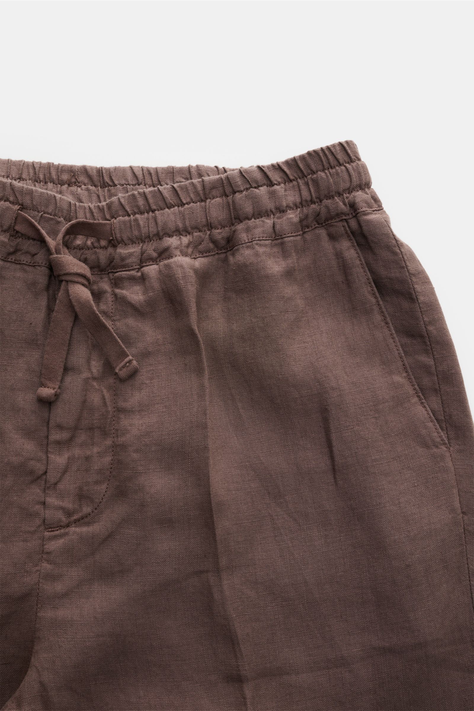 Nahaufnahme der Altea Leinen-Jogpants 'Mattia' graubraun mit elastischem Bund, Tunnelzug, Eingrifftasche und weichem Leinenstoff aus schräger Perspektive.