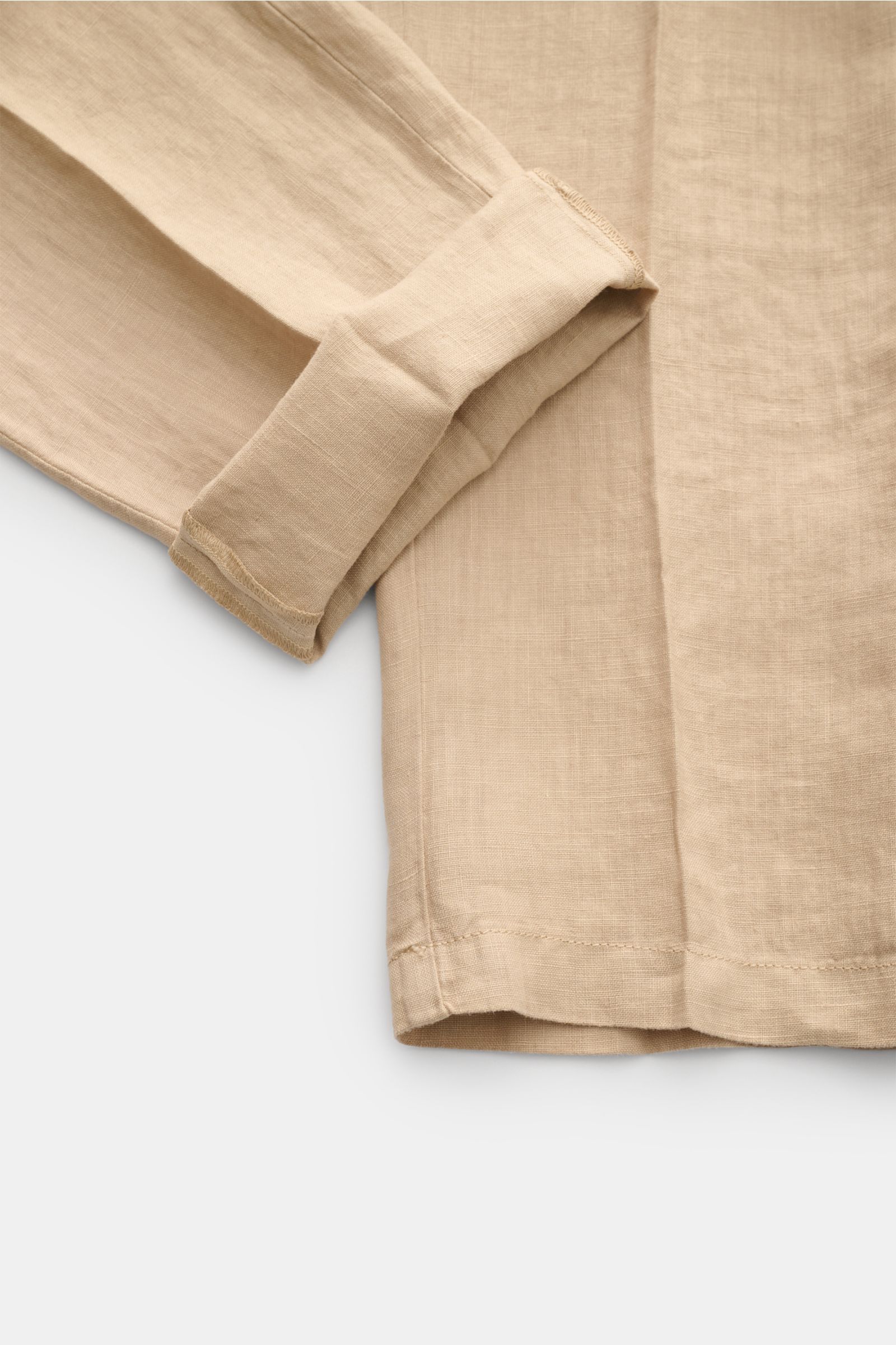 Close-up of Altea Linen jogger pants 'Mattia' beige showing lightweight pure linen fabric, tapered ankle-length leg, and folded cuff from a top-down perspective. Casual luxury for warm days: The jogger pants 'Mattia' in pure linen by ALTEA are the perfect