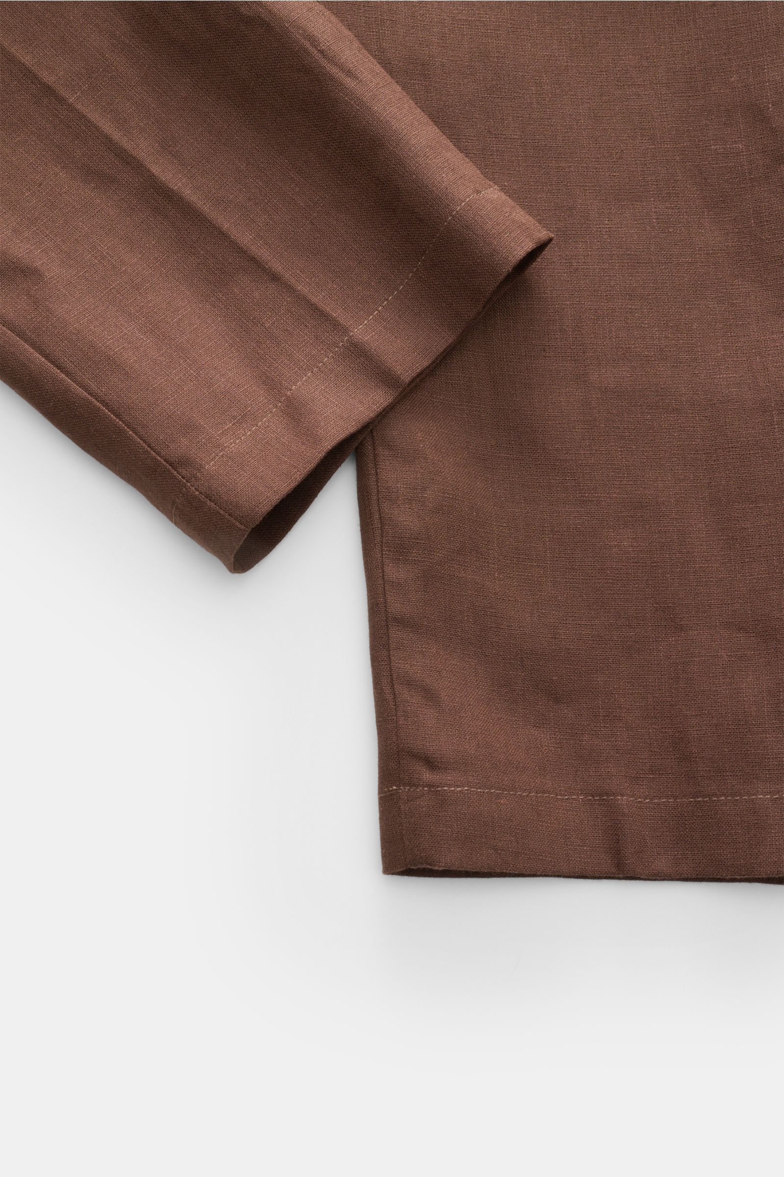 Close-up view of Aurélien Leinen-Jogpants dunkelbraun showing the linen fabric texture and hem details from the bottom perspective. Luxuriöse Lässigkeit für warme Tage: Die Leinen-Jogpants von AURÉLIEN überzeugt mit natürlicher Materialität und elastische