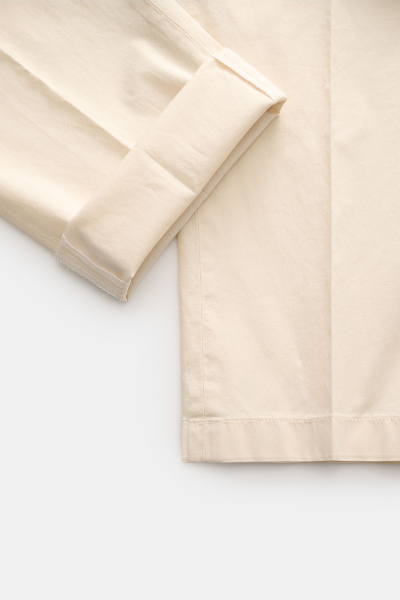 Hiltl Chino 'Primo' creme shown from a close-up side angle, highlighting the folded cuff and smooth cotton twill fabric. Vielseitiges Essential: Die Chino 'Primo' von HILTL überzeugt mit klarer Silhouette, elastischer Qualität, weichem Griff, Regular Fit,