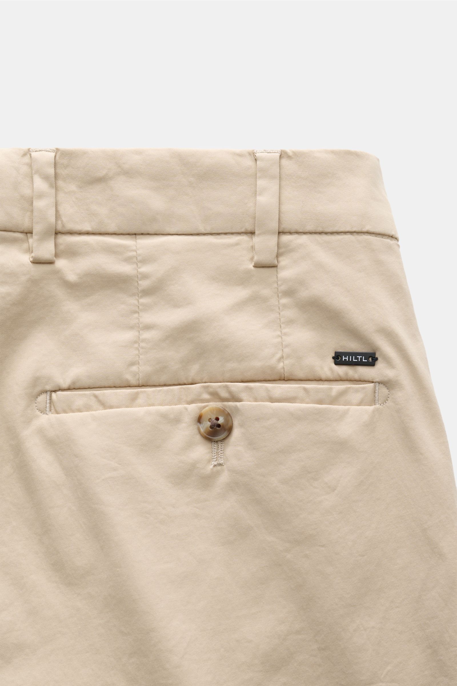 Close-up rear view of Hiltl Chino 'Primo' sand showing back pocket with button, belt loops, and HILTL logo tag on soft cotton twill fabric. Vielseitiges Essential: Die Chino 'Primo' von HILTL im überzeugt mit ihrer klaren Silhouette und lässt sich mühe