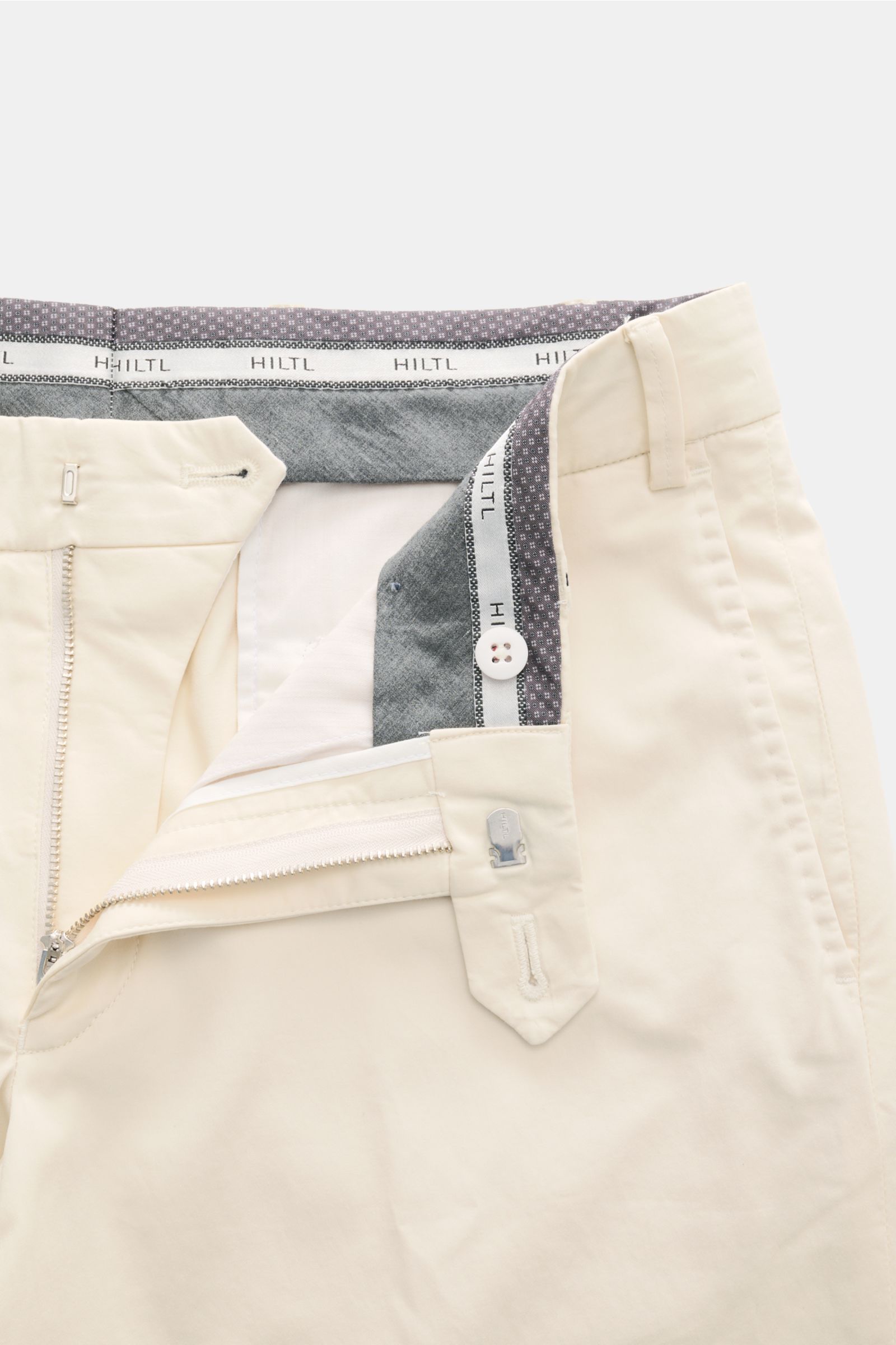Hiltl Baumwollhose 'Peaker' creme von oben, geöffnet mit Zip Fly, Bundknopf, französischen Taschen, leicht elastisch, Regular Fit, glatter Griff.