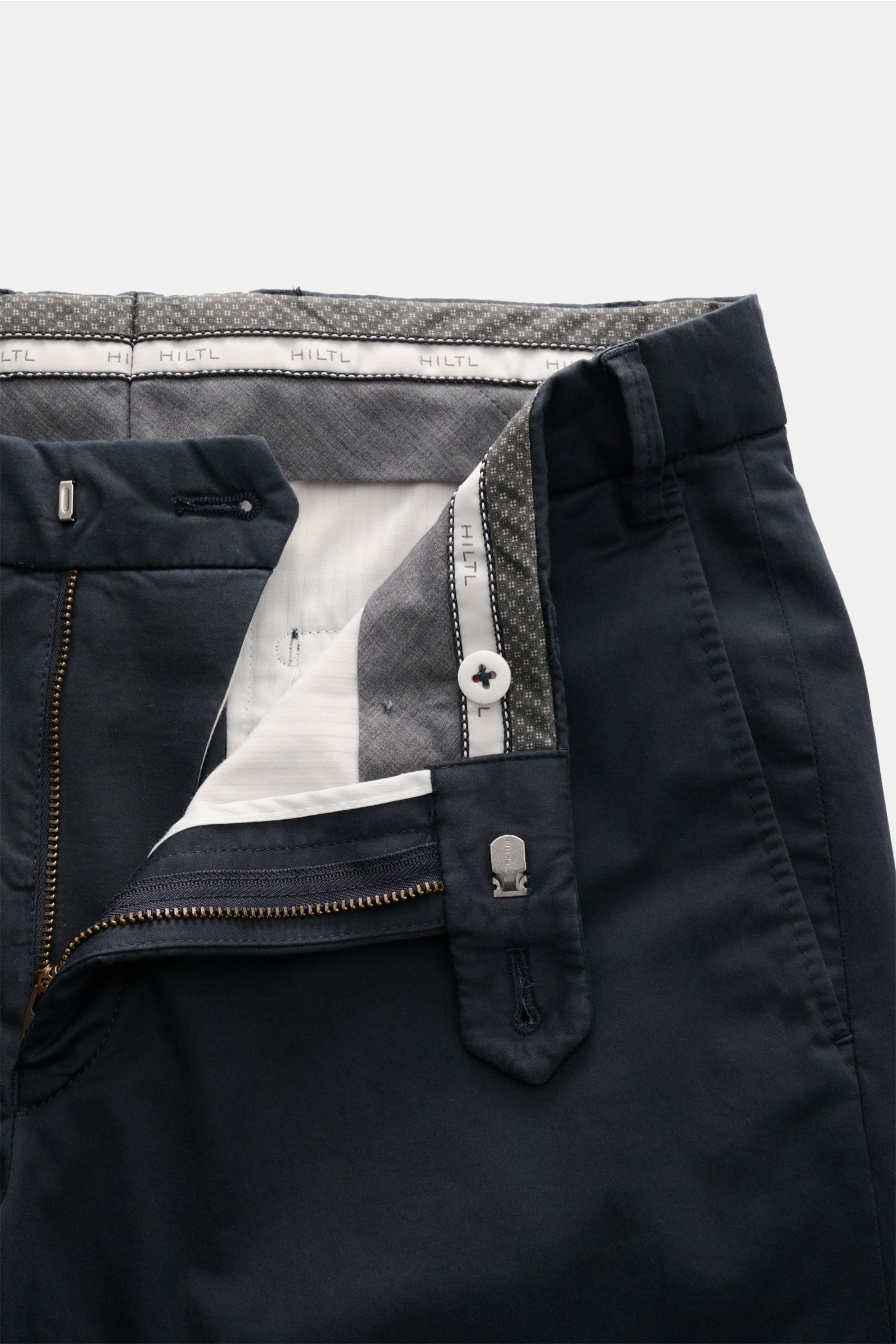 Close-up front view of Hiltl Cotton trousers 'Peaker' navy showing lightweight cotton poplin fabric, zip fly, waist button, and interior lining. Lightweight trousers for every day: With the model 'Peaker' in a regular fit, HILTL has created a pair of ligh