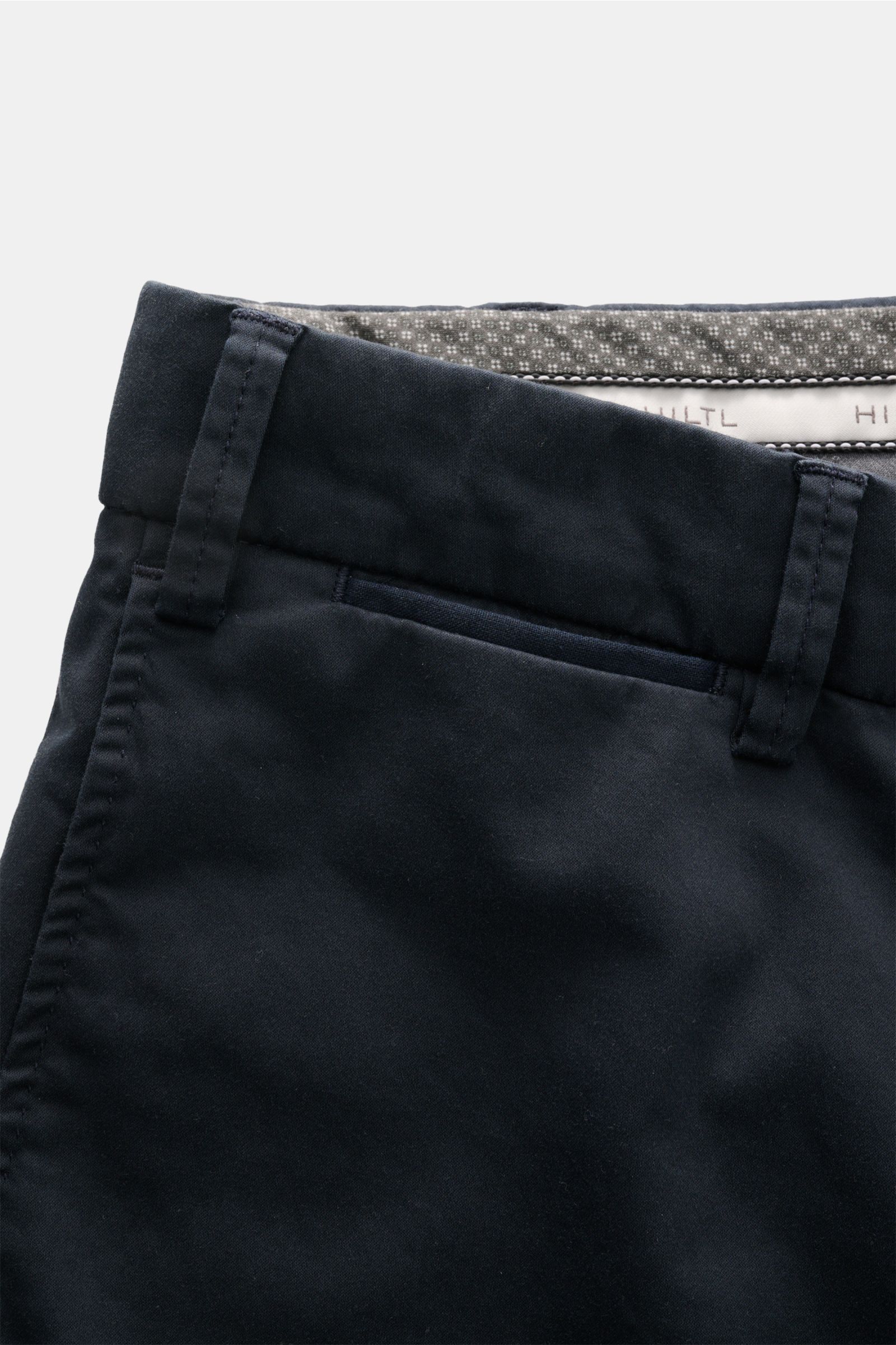 Close-up front view of Hiltl Cotton trousers 'Peaker' navy showing waistband, belt loops, and French pocket. Lightweight cotton poplin fabric with slight stretch and smooth feel. Features regular fit, slightly tapered cut, zip fly, waist button, and jette