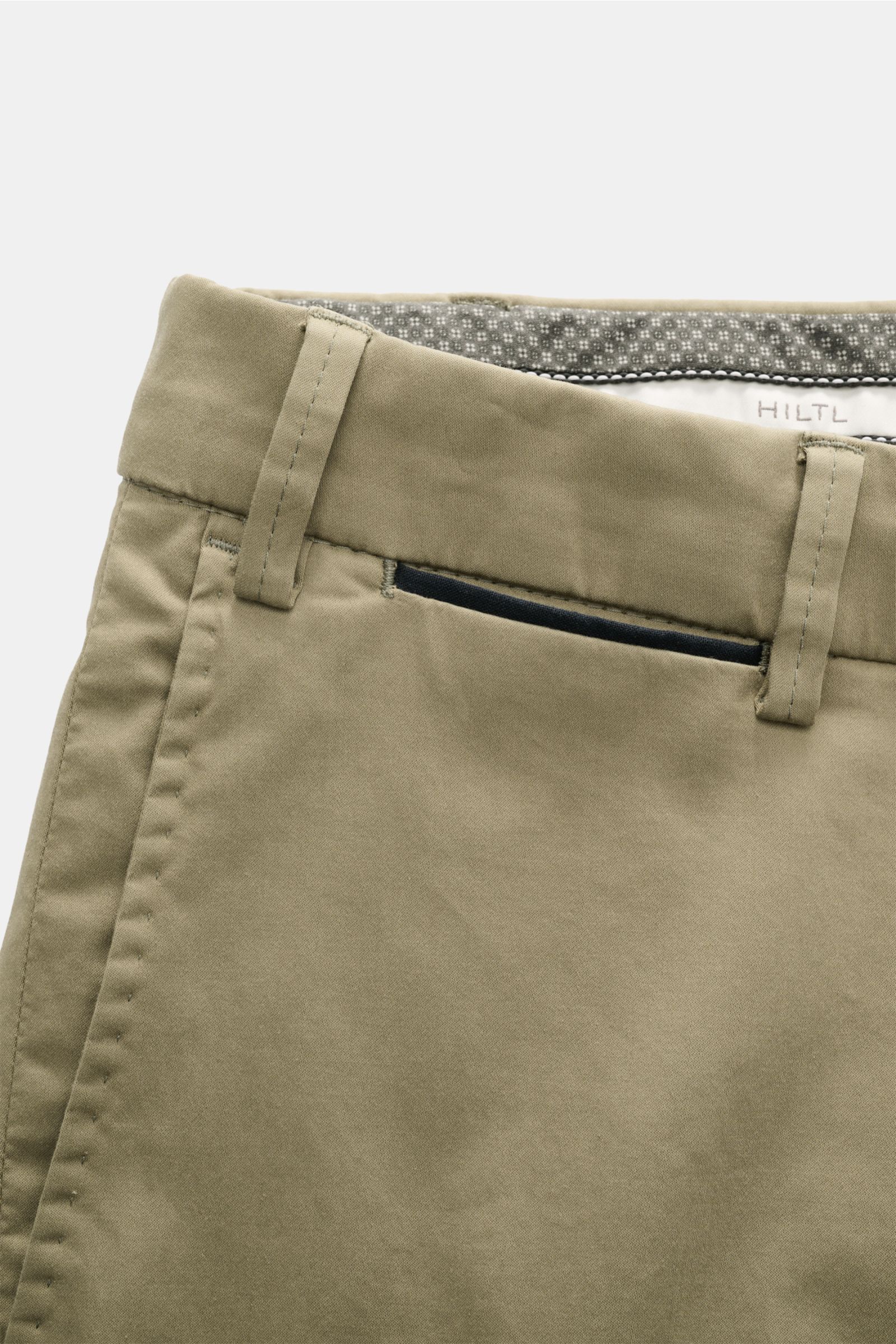 Close-up front view of the olive Hiltl Baumwollhose 'Peaker' showing belt loops and pocket with black trim, made of lightweight cotton poplin with stretch. Die leichte Hose für jeden Tag: HILTL kreiert mit dem Modell 'Peaker' im Regular Fit eine leichte B