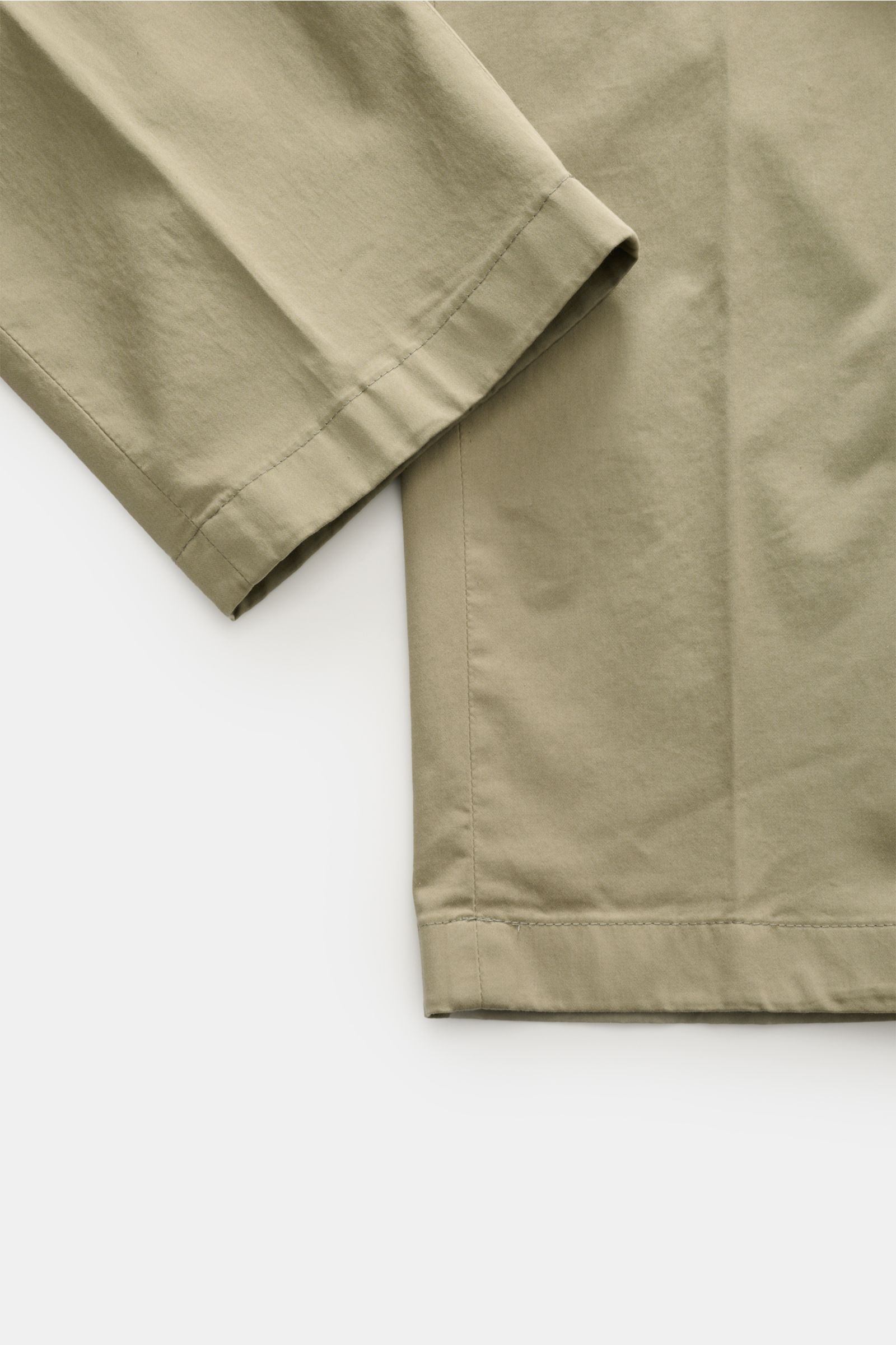 Close-up front view of olive Hiltl Baumwollhose 'Peaker' showing lightweight cotton fabric with slight stretch, smooth texture, and clean hem. The lightweight pants for everyday wear: HILTL creates with the model 'Peaker' in Regular Fit a light cotton pan