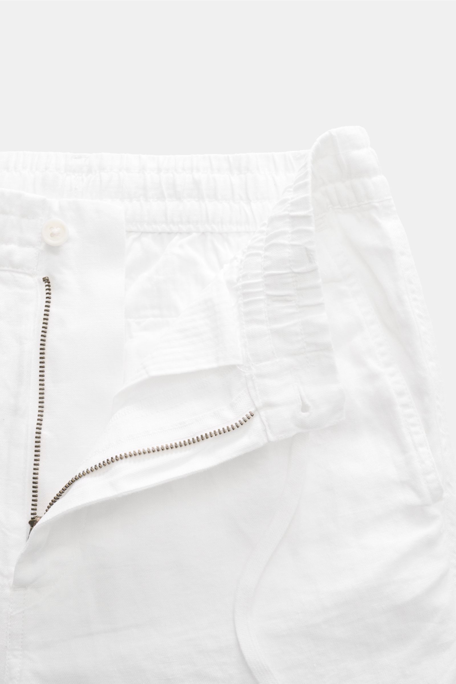 Nahaufnahme der geöffneten Taille der Polo Ralph Lauren Leinenhose weiß mit elastischem Bund, Tunnelzug, Reißverschluss, Bundknopf und französischen Taschen.