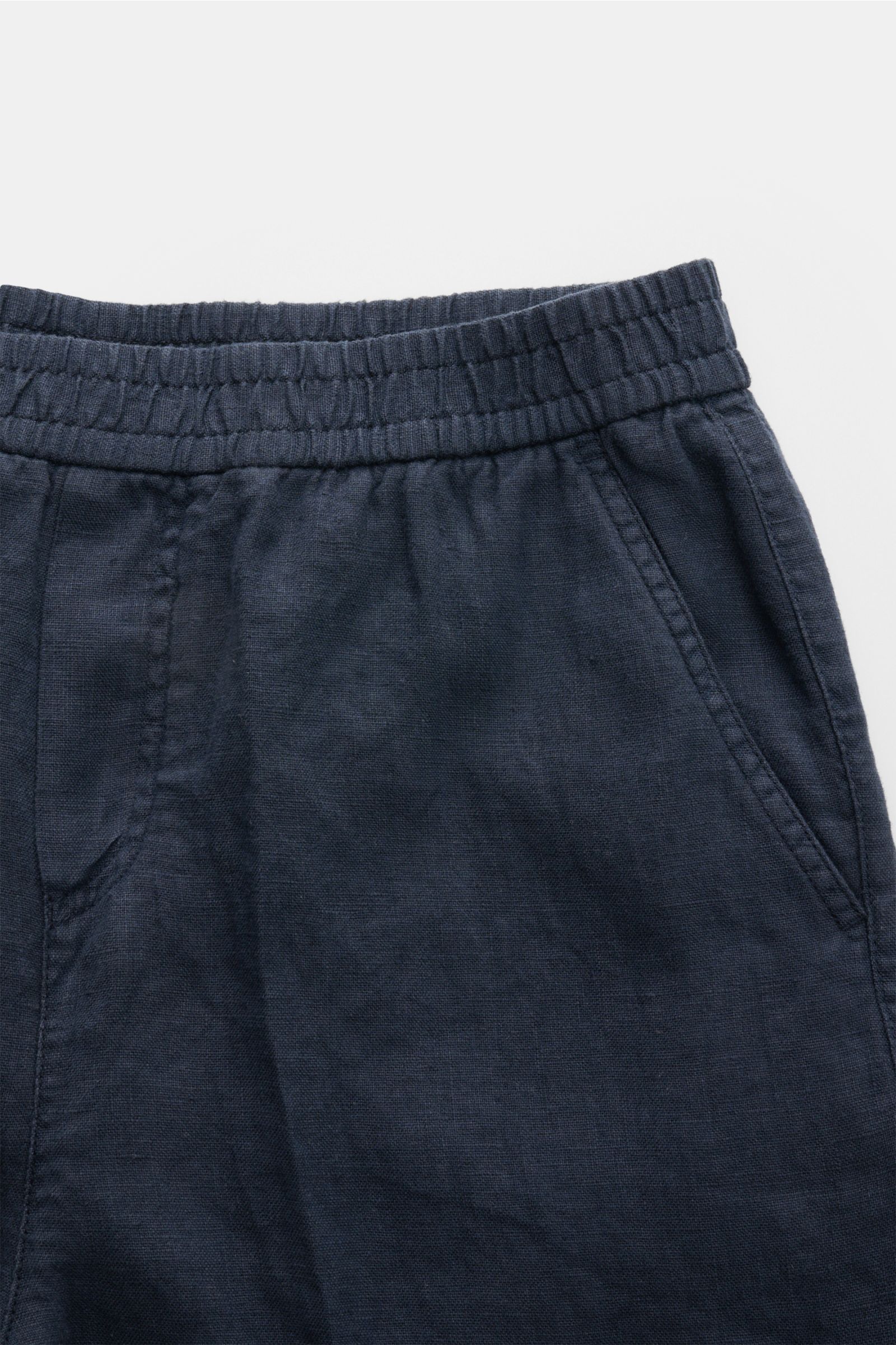 Nahaufnahme der elastischen Bundzone der 04651/ A trip in a bag Leinen-Jogpants 'Linen Pants' navy aus reinem Leinen mit typischer Struktur, französischen Taschen und kleinem Weblabel, perfekt für warme Tage.