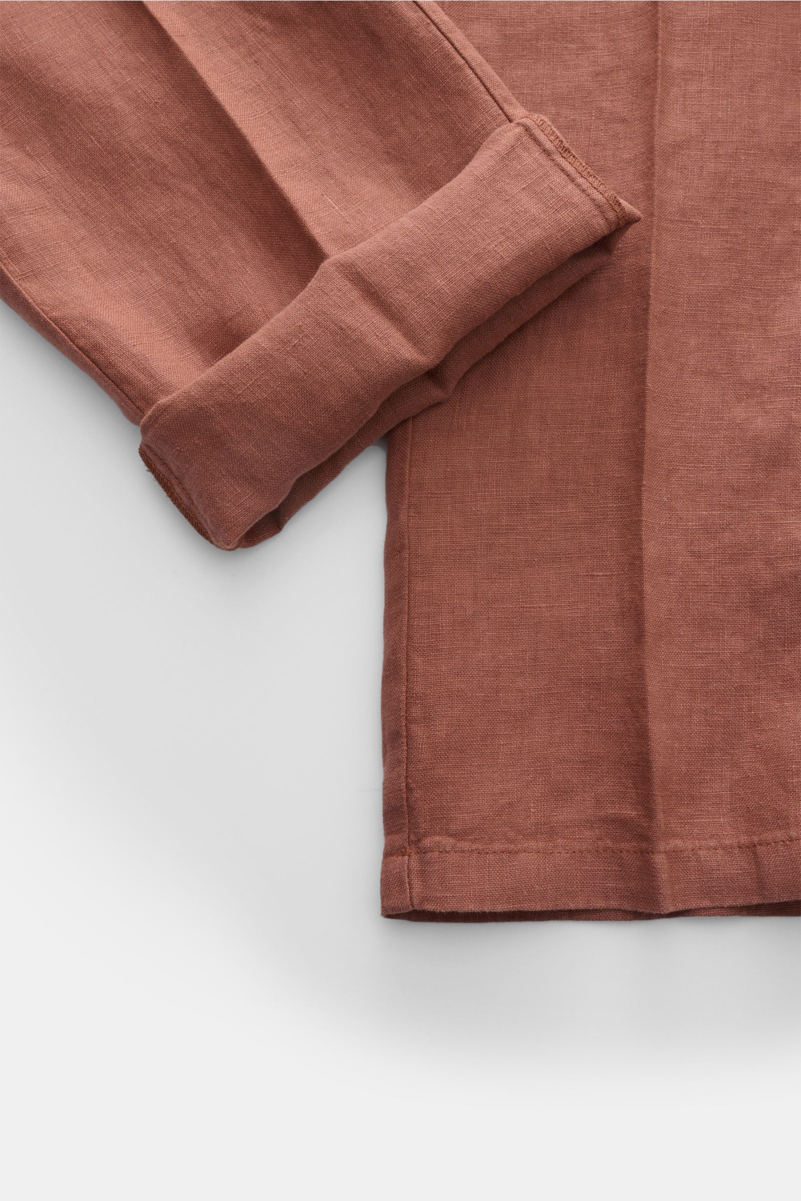 Nahaufnahme der gekrempelten Beinöffnung einer rostbraunen 04651/ A trip in a bag Leinen-Jogpants 'Linen Pants' aus purem Leinen mit typischer Struktur.