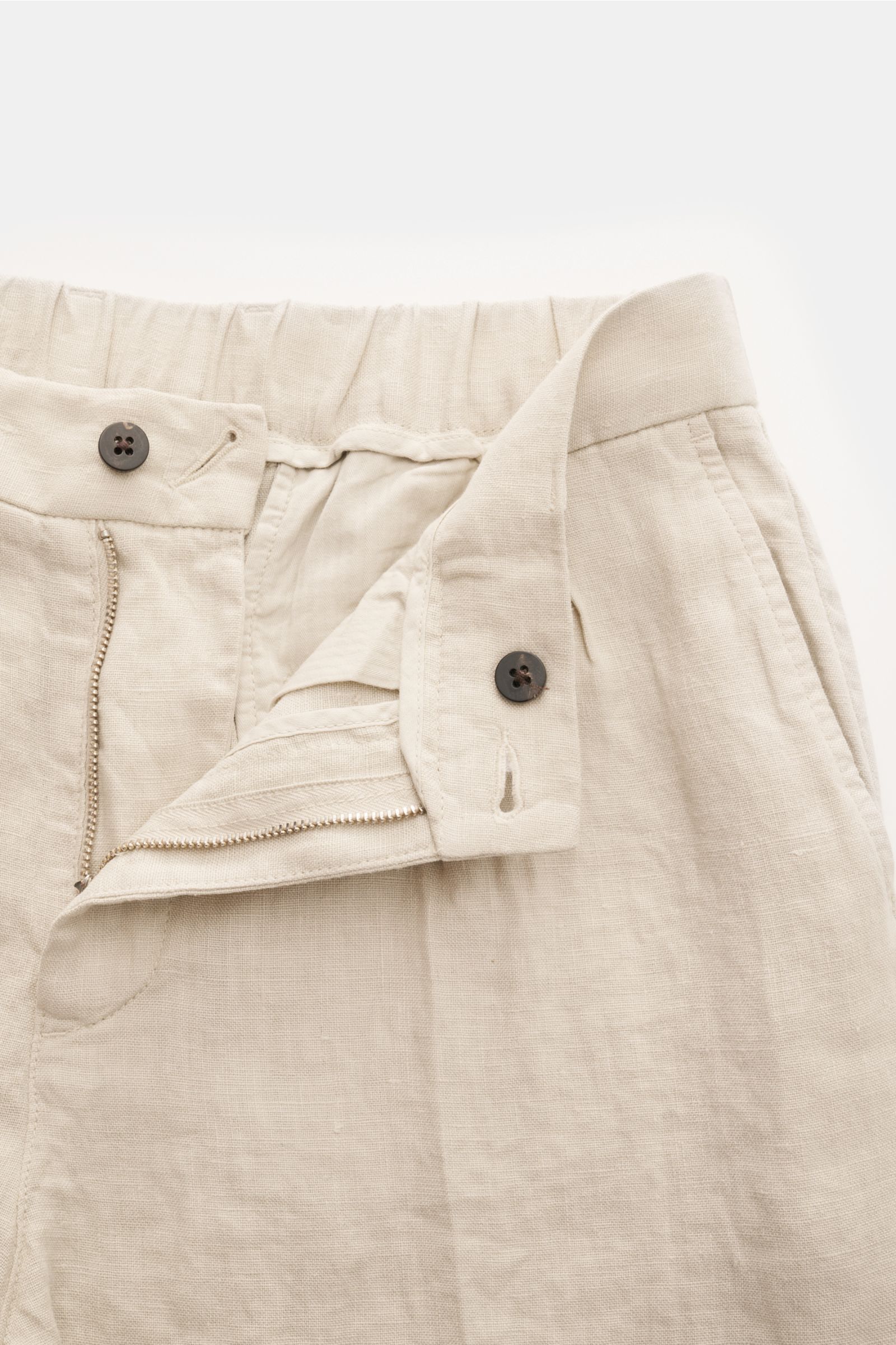 Close-up front view of 04651/ A trip in a bag Linen jogger pants 'Linen Pants' beige showing zipper, button, and partially elasticated waistband.

Perfect for warm days: These linen jogger pants by 04651/ A TRIP IN A BAG are the ideal summer essential 