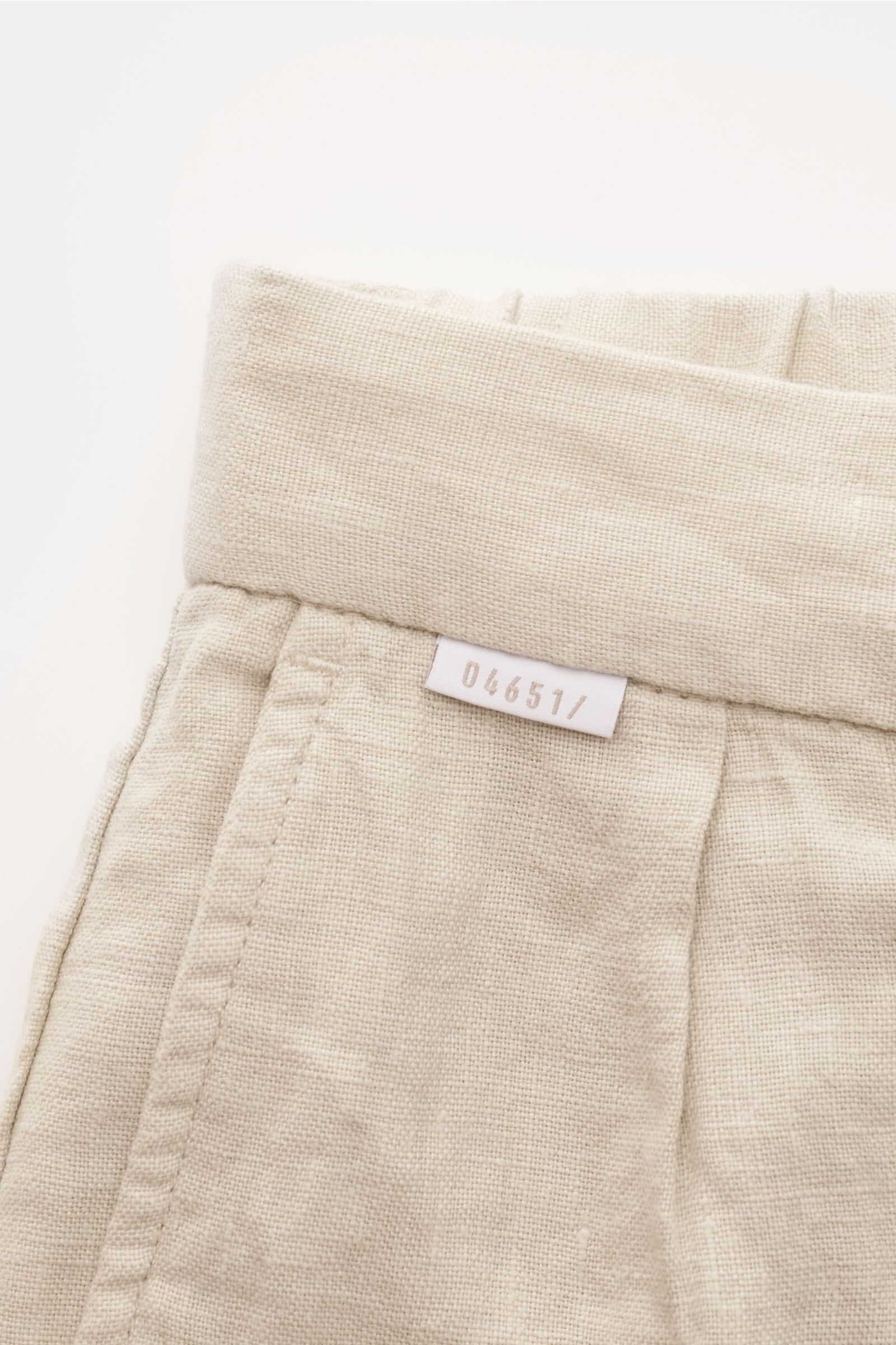 Close-up top view of the waistband and label on 04651/ A trip in a bag Linen jogger pants 'Linen Pants' beige showing pure linen fabric and textured weave.

Perfect for warm days: These linen jogger pants by 04651/ A TRIP IN A BAG are the ideal summer 