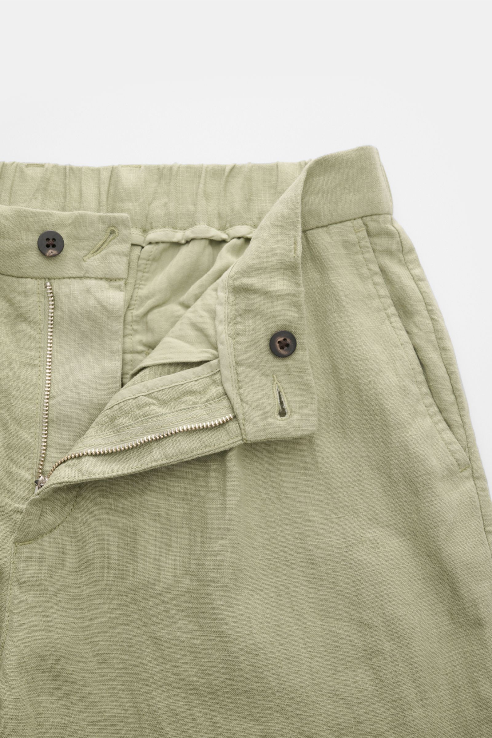 04651/ A trip in a bag Leinen-Jogpants 'Linen Pants' salbei, Detailfoto von vorne, Reißverschluss offen, Bund mit Knopf, französische Taschen, reines Leinen.