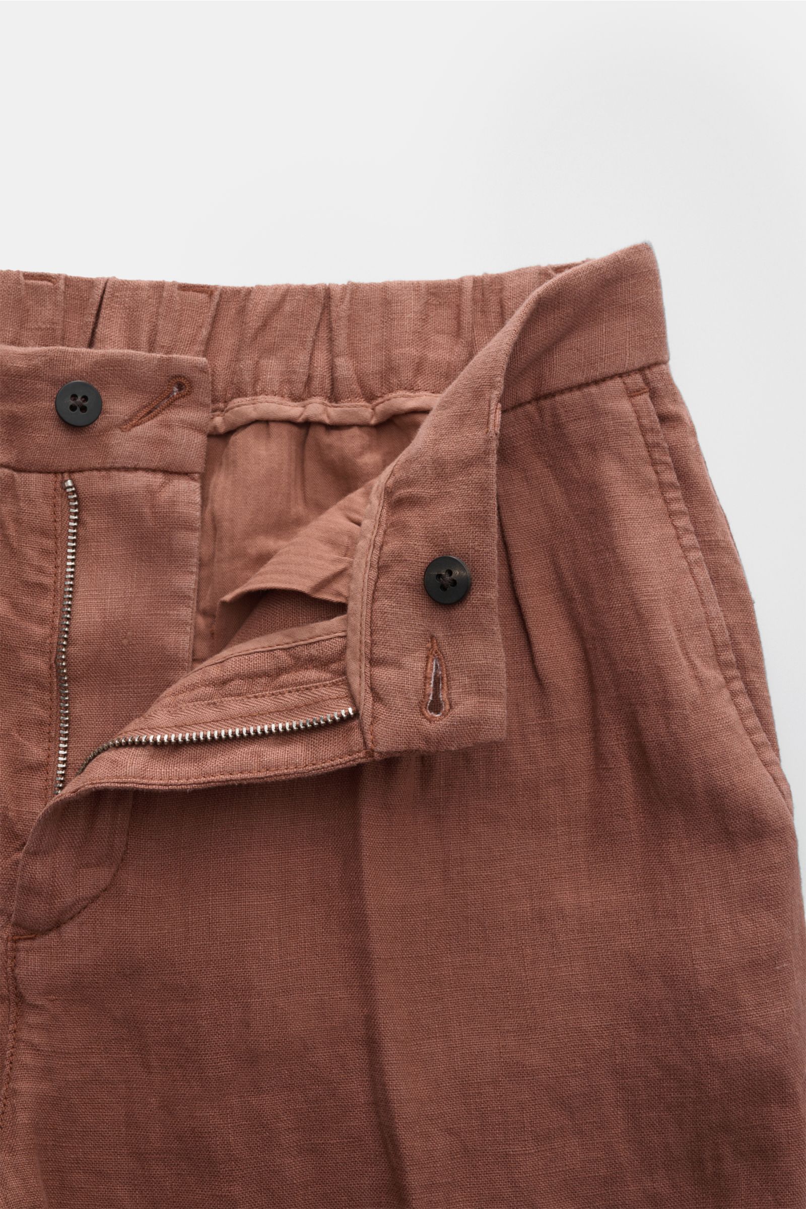 Close-up front view of 04651/ A trip in a bag Linen jogger pants 'Linen Pants' rust brown showing zip, button, and linen texture.

Perfect for warm days: These linen jogger pants by 04651/ A TRIP IN A BAG are the ideal summer essential – for travel or 