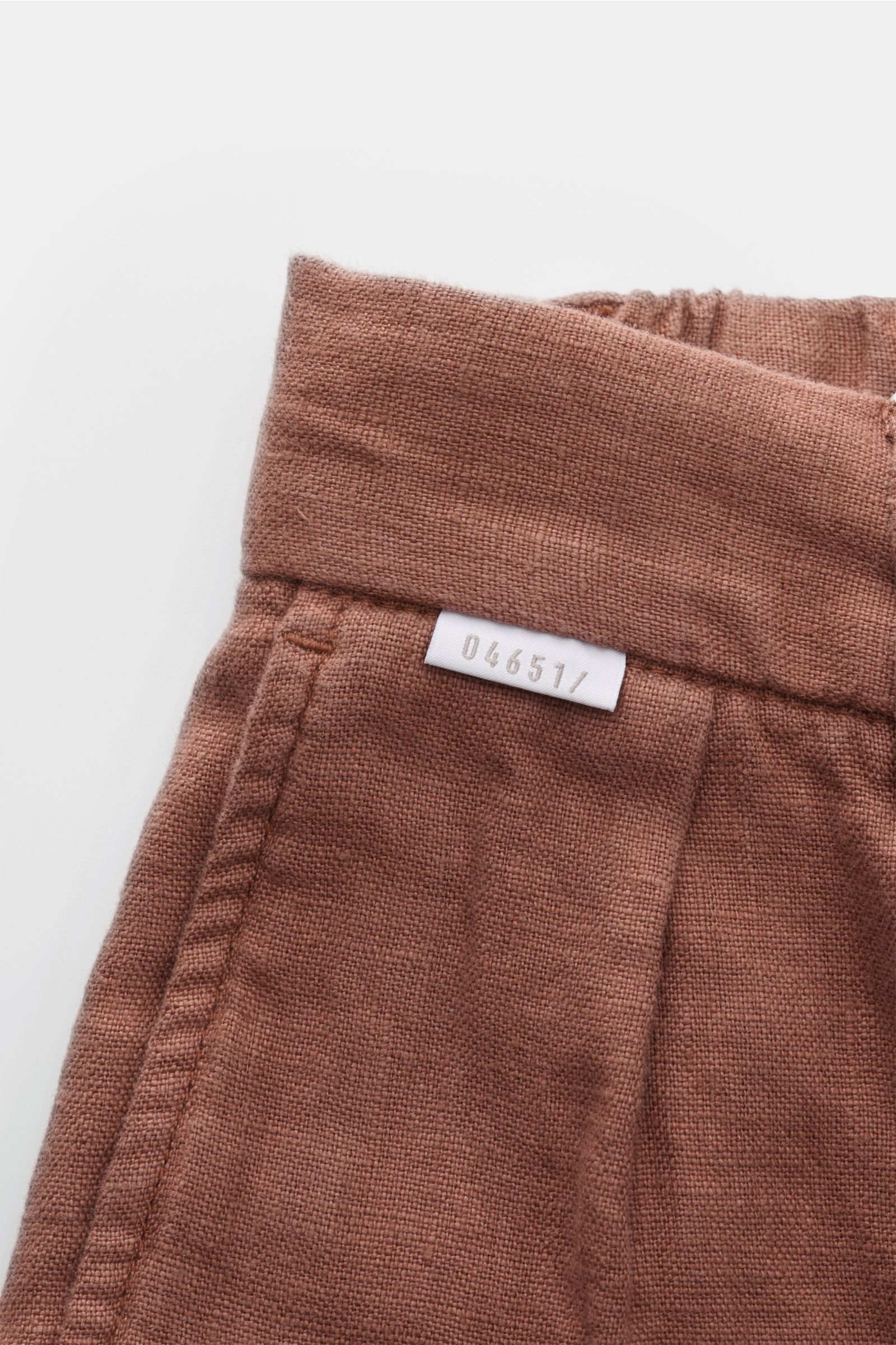 Close-up front view of 04651/ A trip in a bag Linen jogger pants 'Linen Pants' rust brown showing linen texture and white brand label.

Perfect for warm days: These linen jogger pants by 04651/ A TRIP IN A BAG are the ideal summer essential – for travel o