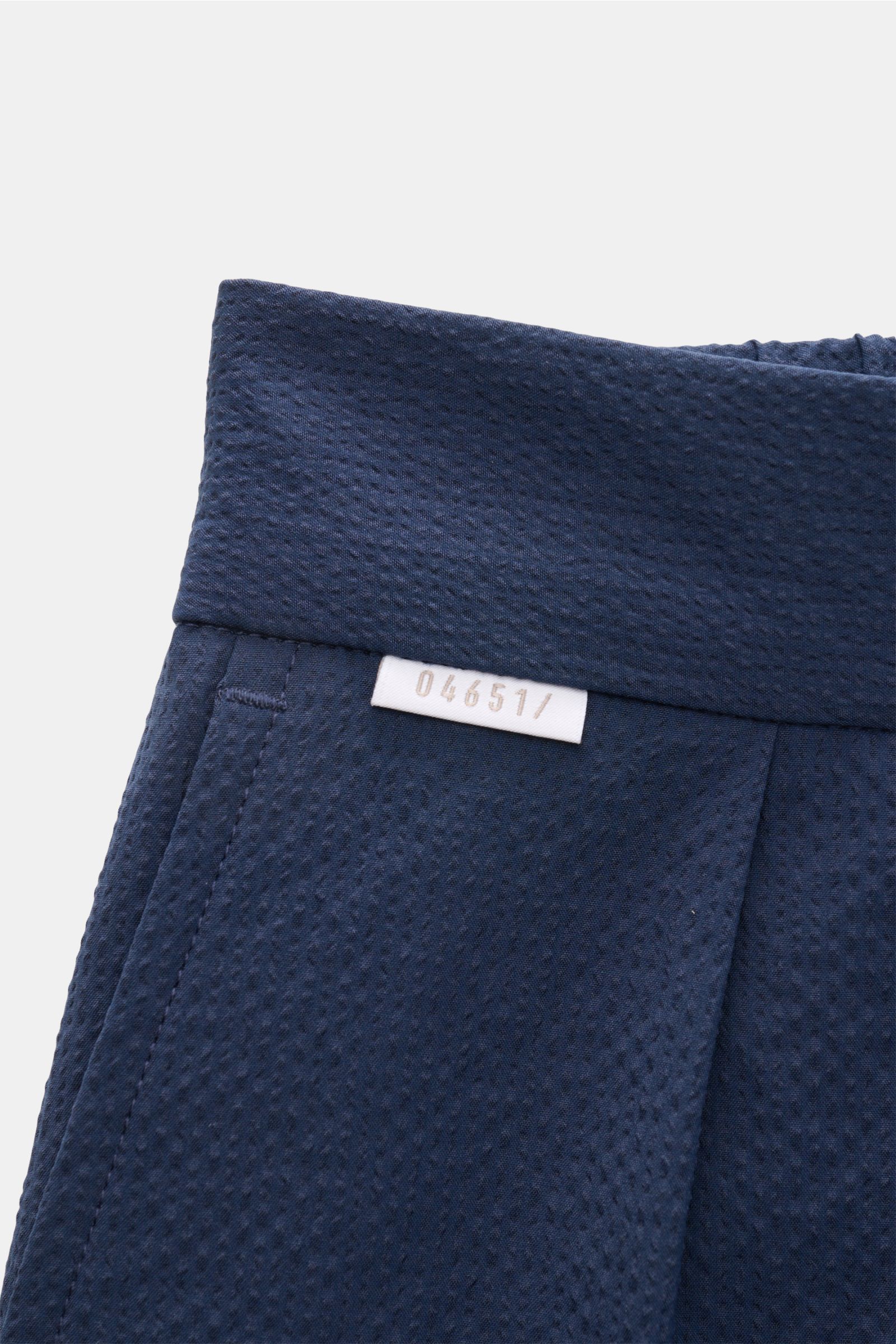 Nahaufnahme der Bundpartie der 04651/ A trip in a bag Seersucker-Hose 'Technical Seersucker' navy, Tapered Fit, Seersucker Microfaser, strukturierte, griffige Qualität, doppelte Bundfalte, dezentes Weblabel.