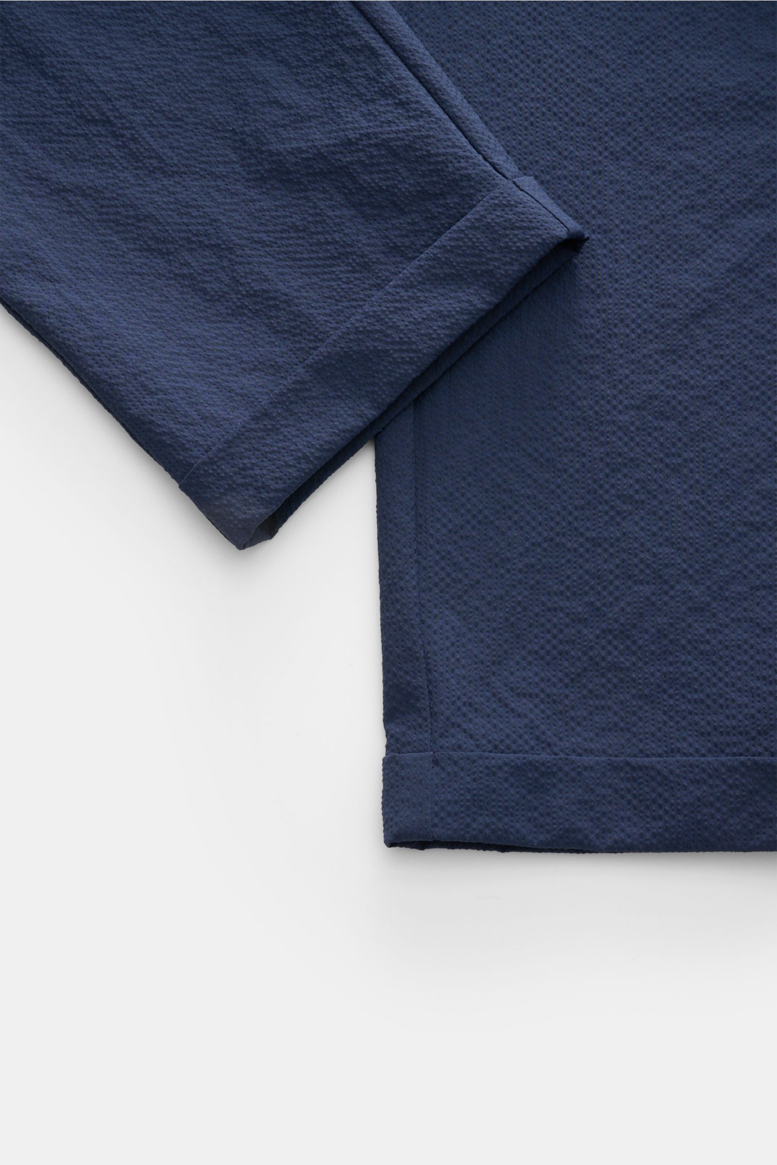 Nahaufnahme der knöchellangen 04651/ A trip in a bag Seersucker-Hose 'Technical Seersucker' navy aus Microfaser-Seersucker, feine Struktur, Tapered Fit, Bund mit Reißverschluss, Bundknopf, doppelte Bundfalte, französische Taschen, Leistentaschen am Gesäß,