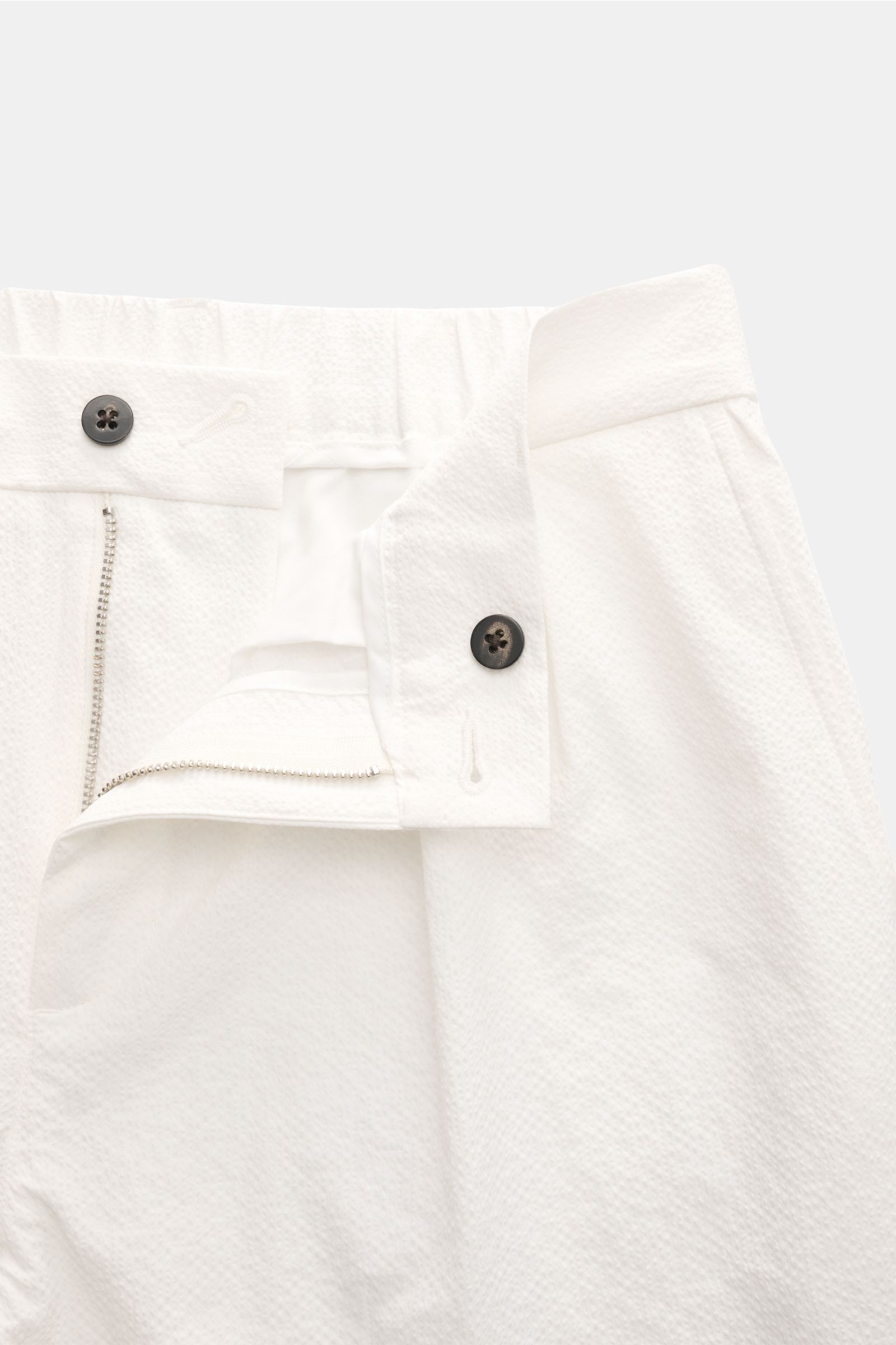 04651/ A trip in a bag Seersucker-Hose 'Technical Seersucker' offwhite, Detailaufnahme von vorne, Seersucker Microfaser, feine Struktur, griffig, Tapered Fit, reguläre Oberschenkelweite, knöchellang, Reißverschluss, Bundknopf, doppelte Bundfalte, französi