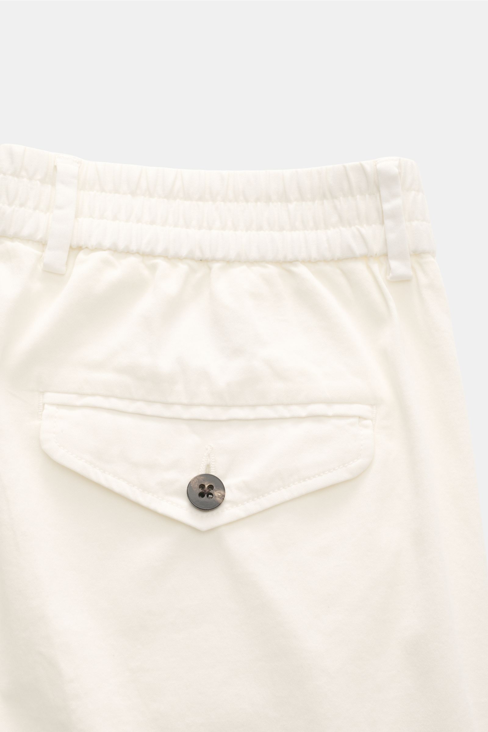 Close-up rear view of 04651/ A trip in a bag Cotton jogger pants 'Flex Light' cream showing elasticated waistband, button flap back pocket, and soft cotton fabric.