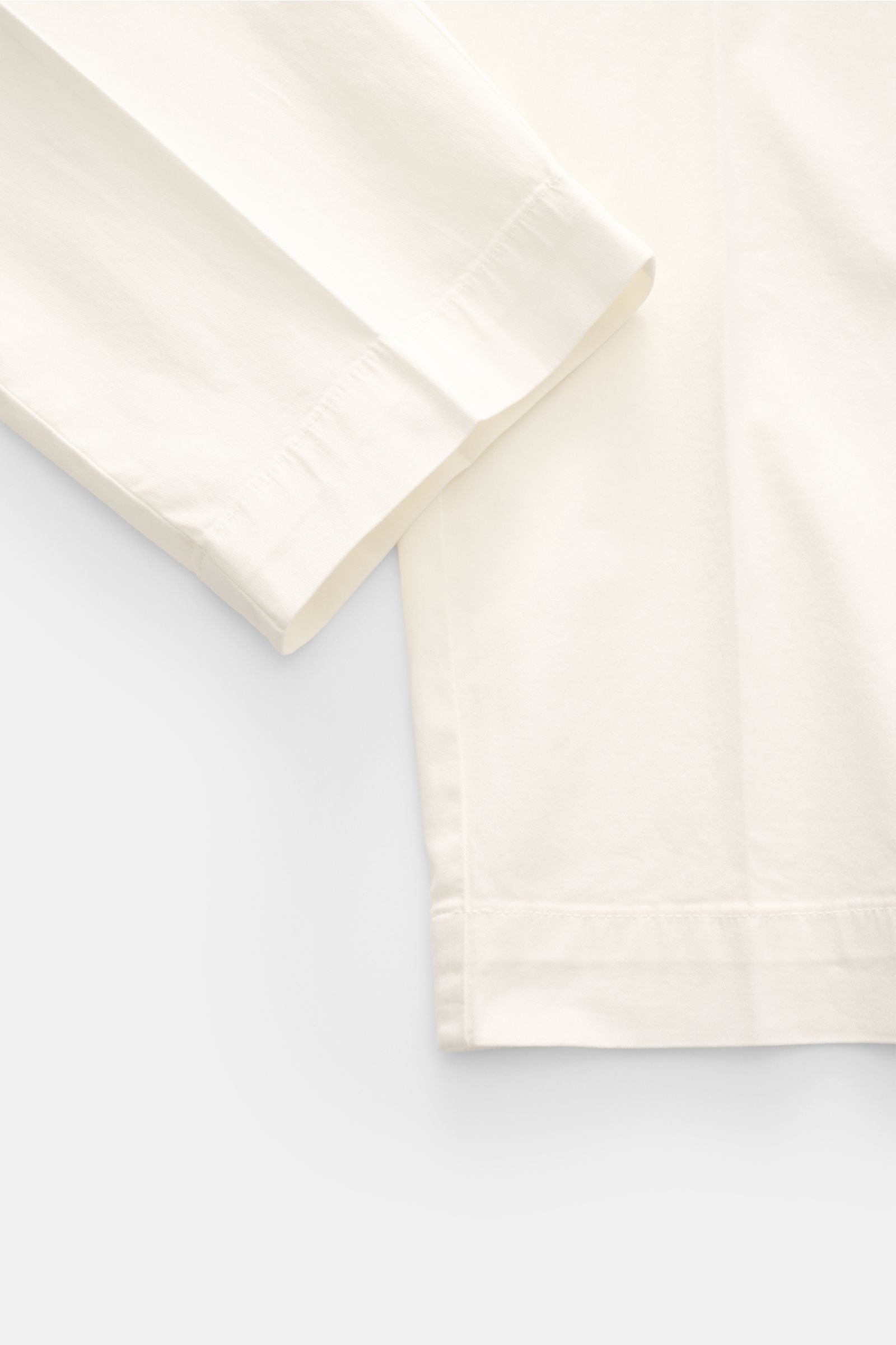 Close-up front view of 04651/ A trip in a bag Cotton jogger pants 'Flex Light' cream, elasticated cotton, soft feel, regular fit, short and very tapered cut with zip, waist button, partially elasticated waistband, small woven label, French pockets, and ba