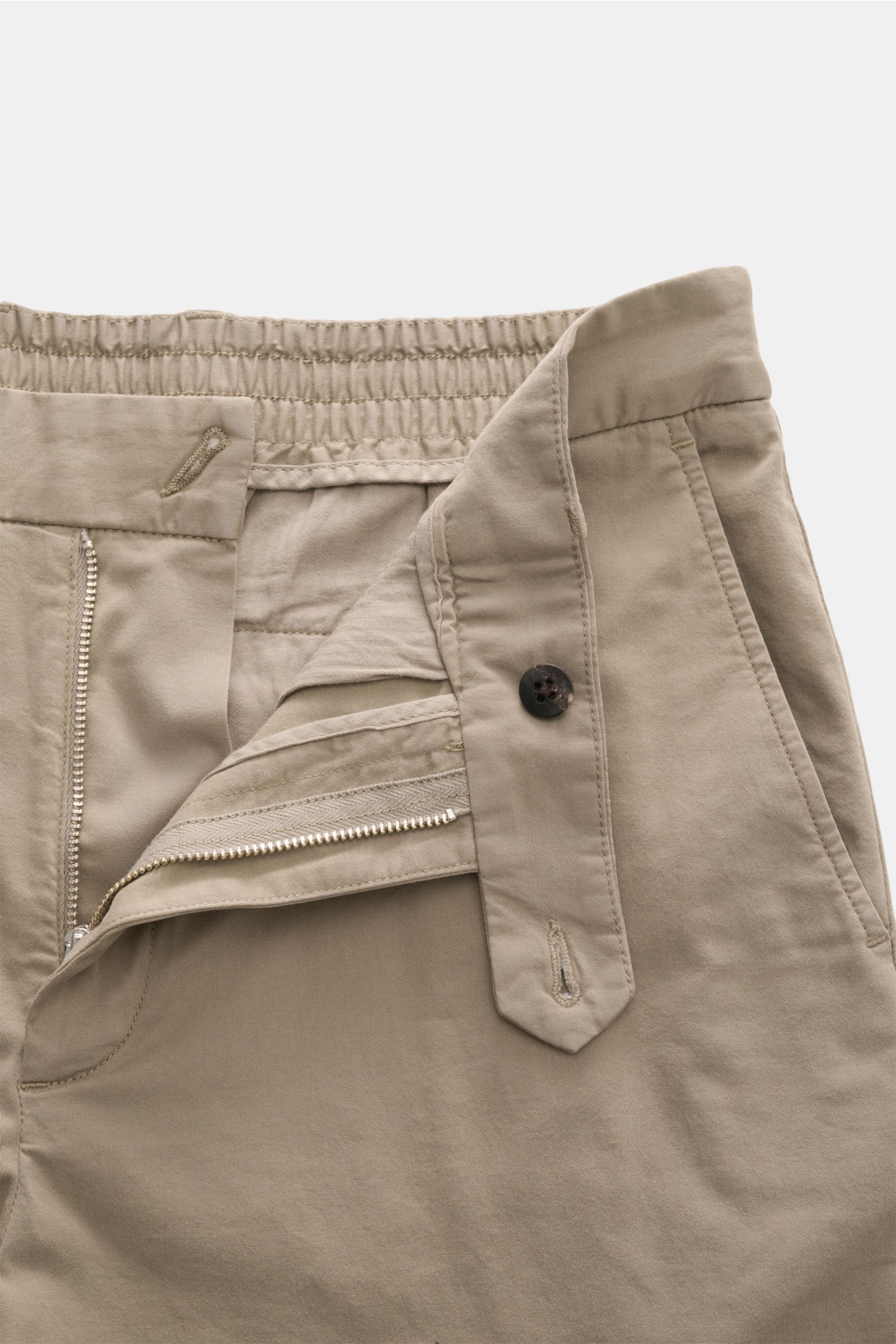 Frontansicht der geöffneten 04651/ A trip in a bag Baumwoll-Jogpants 'Flex Light' taupe mit elastischem Bund, Reißverschluss, Bundknopf und französischen Taschen.