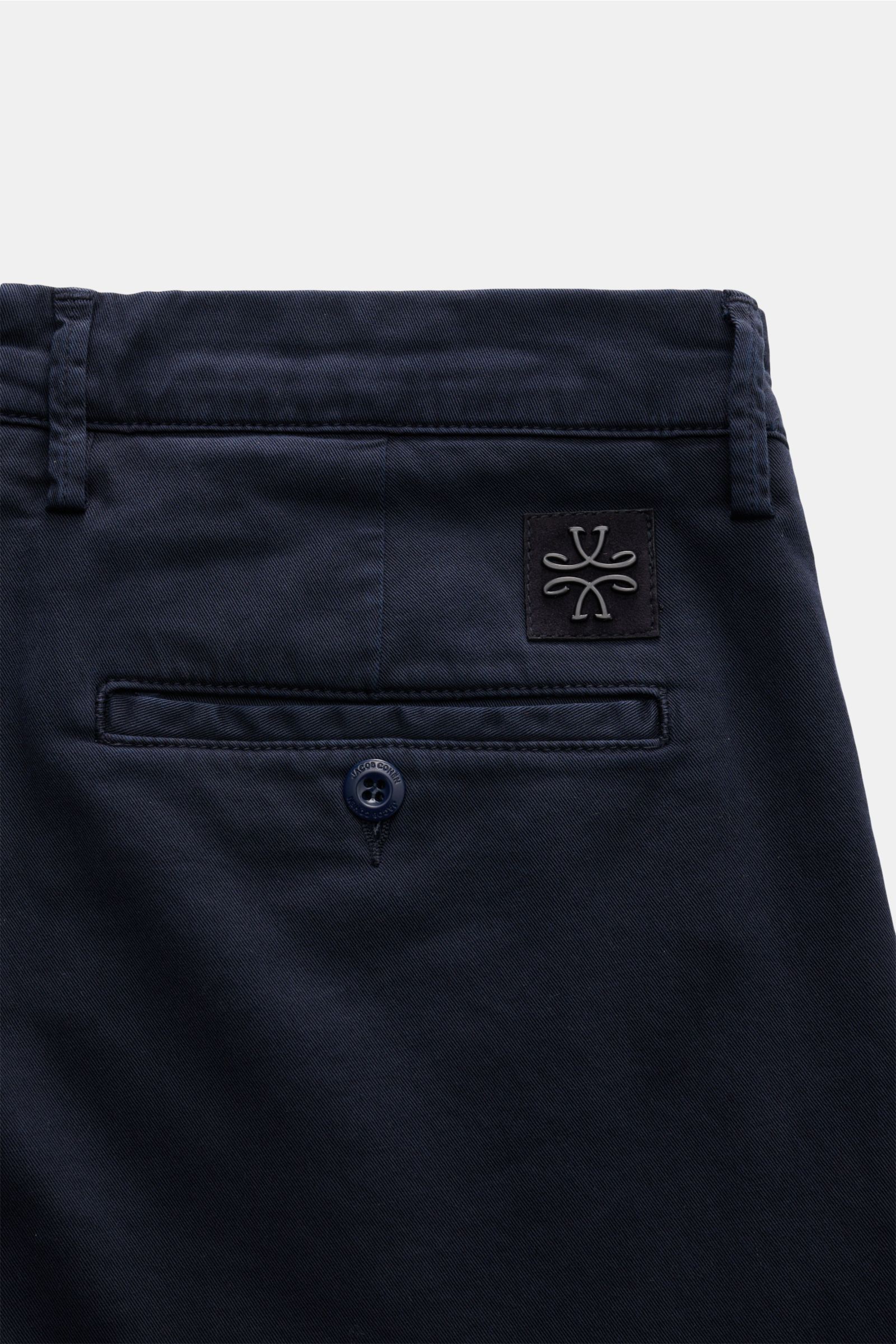 Close-up rear view of Jacob Cohen Chino 'Bobby' navy in slim fit, made of pure elastic cotton with tonal velour leather patch and buttoned back pocket. Setzen Sie auf modernen Luxus im Alltag: Die schmal geschnittene Chino 'Bobby' von JACOB COHEN überzeug