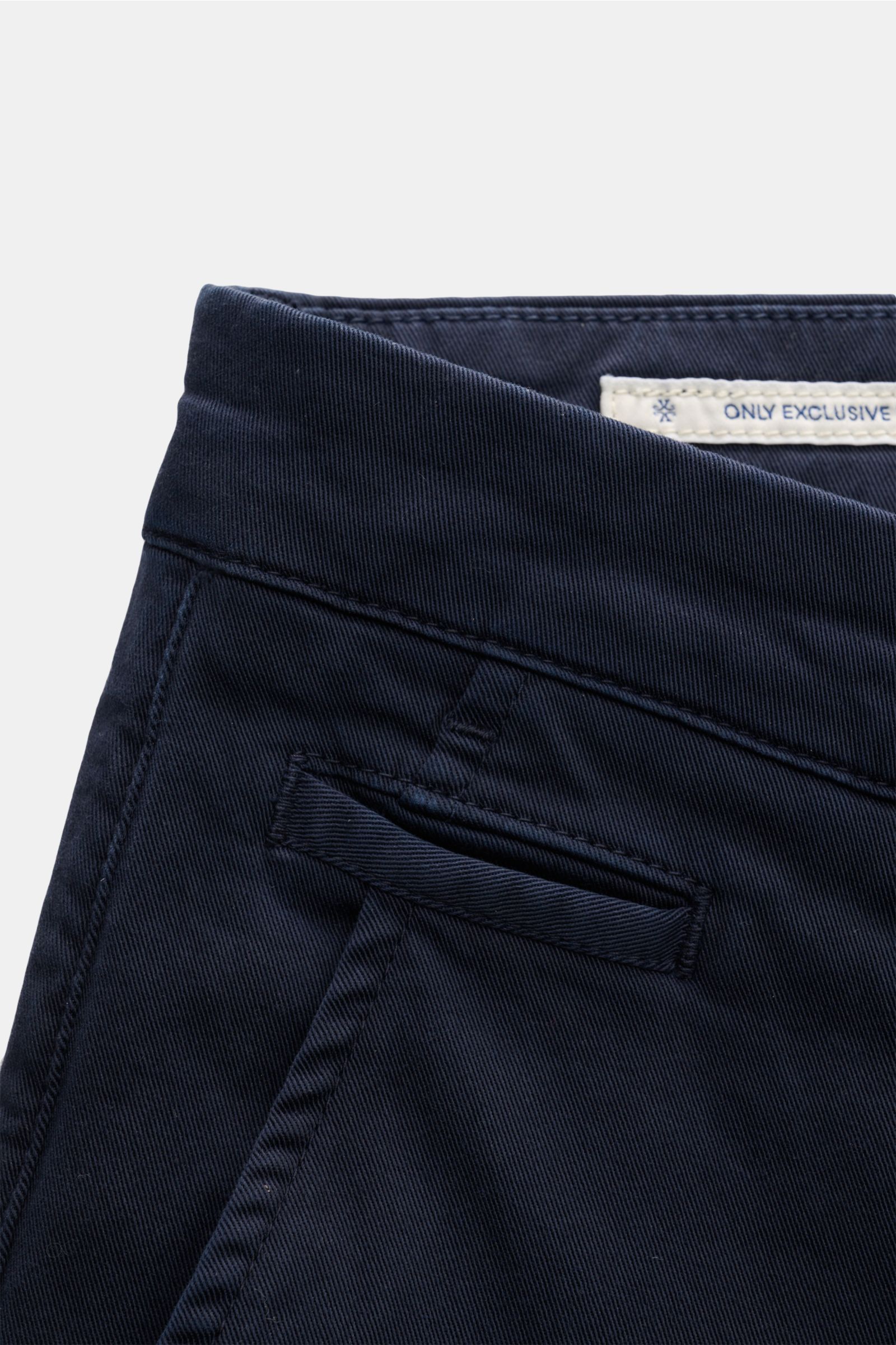 Close-up front side view of the Jacob Cohen Chino 'Bobby' navy, showcasing slim fit, pure elastic cotton, soft texture, French pockets, coin pocket, buttoned back pockets, tonal velour leather patch, zipper, and waistband button. Setzen Sie auf modernen L