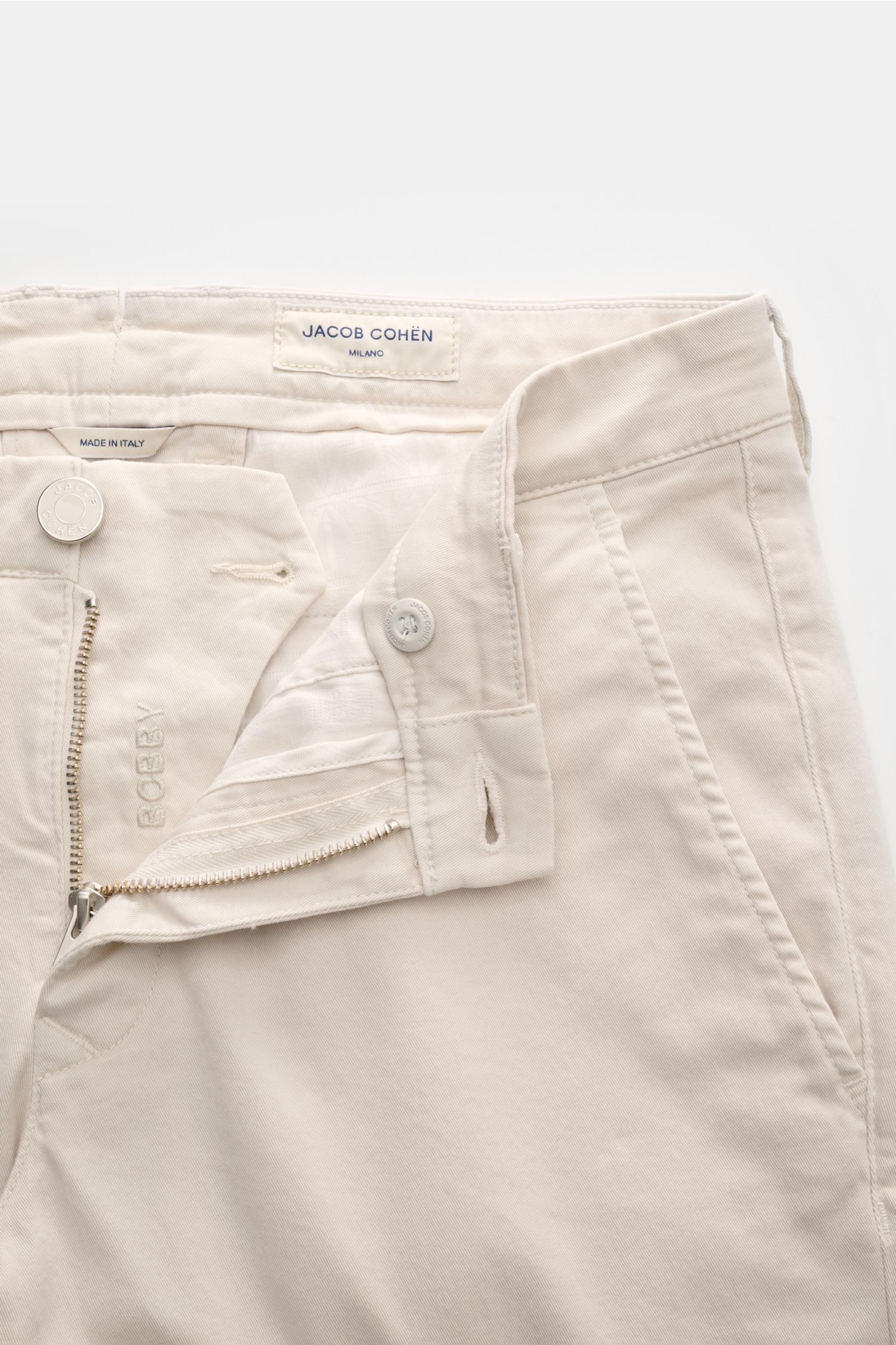 Close-up front view of the Jacob Cohen Chino 'Bobby' sand showing zipper, button, and side pocket details, made of elastic pure cotton.

Description: Setzen Sie auf modernen Luxus im Alltag: Die schmal geschnittene Chino 'Bobby' von JACOB COHEN überzeu