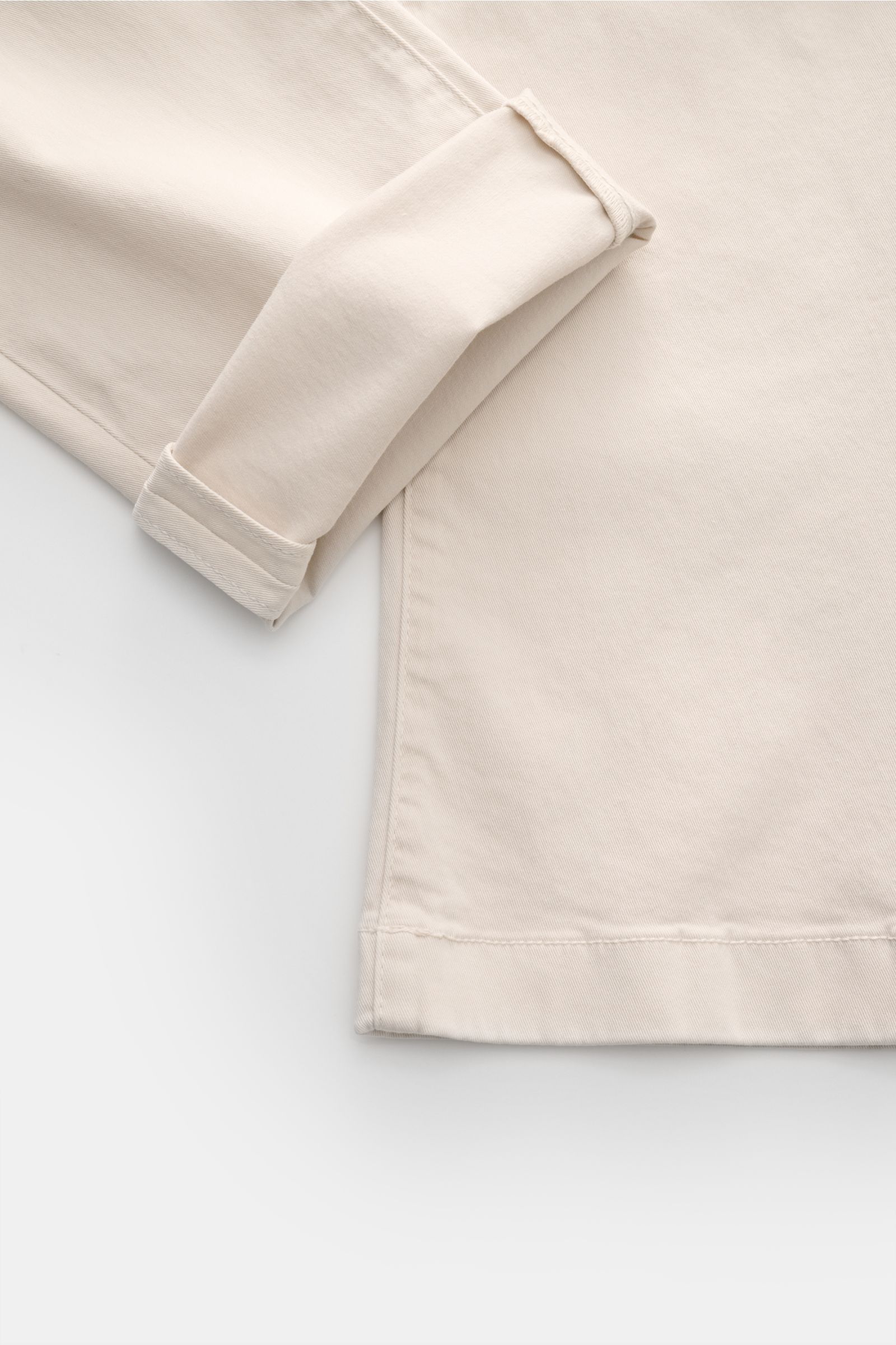 Close-up top view of Jacob Cohen Chino 'Bobby' sand showing folded cuff, slim fit, elastic cotton fabric, and fine stitching details.